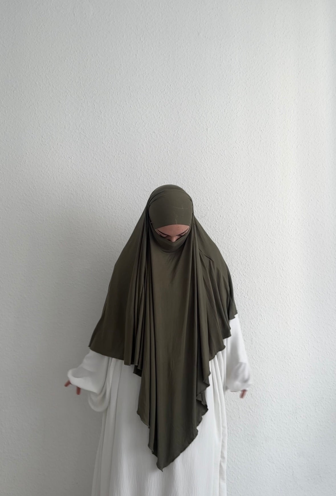 Jersey Khimar in Khaki aus Viskose‑Elastan, frontale Ansicht am Modell mit langer vorderer Partie.