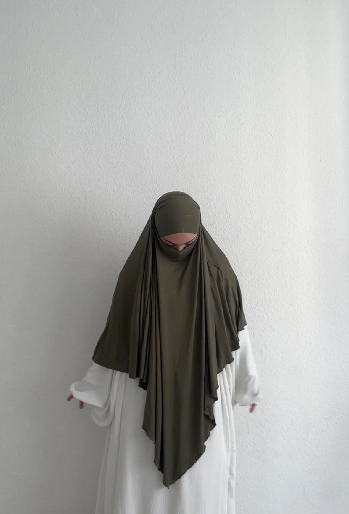 Jersey Khimar in Khaki aus Viskose‑Elastan, frontale Ansicht am Modell mit langer vorderer Partie.
