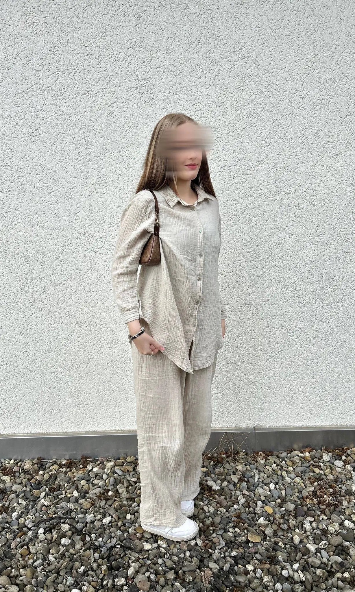 Der beige Musselin-Zweiteiler aus 100% Baumwolle mit Hemdbluse und weiter Hose ist in Seitenansicht dargestellt.