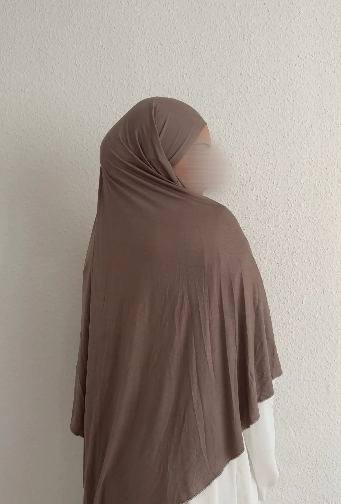 Jersey Khimar aus Viskose-Elastan in Braun, drapiert über Kopf und Rücken, Rückansicht leicht seitlich.
