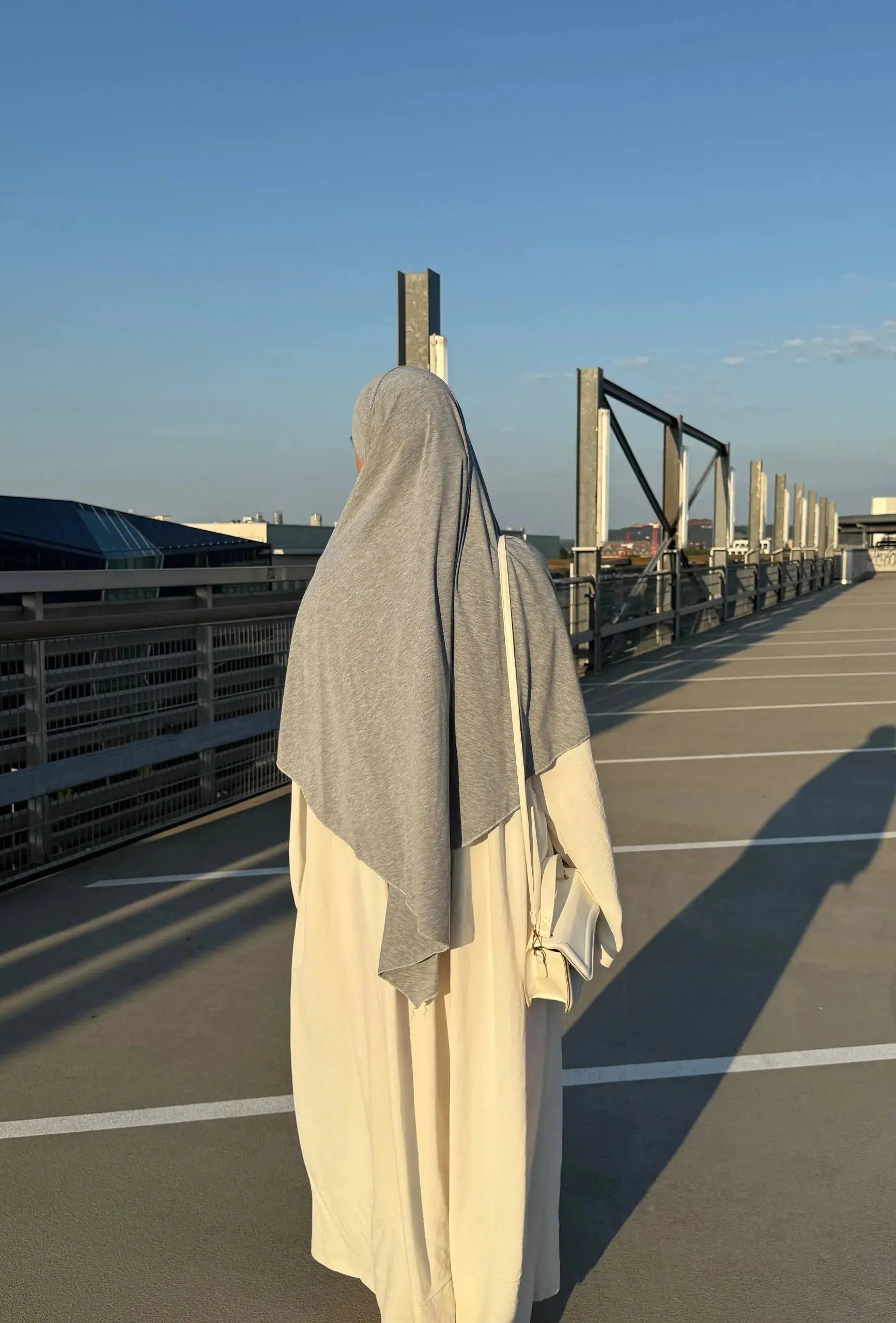 Jersey Khimar in Hellgrau aus Viskose-Elastan, Rückansicht über einer cremefarbenen Robe.