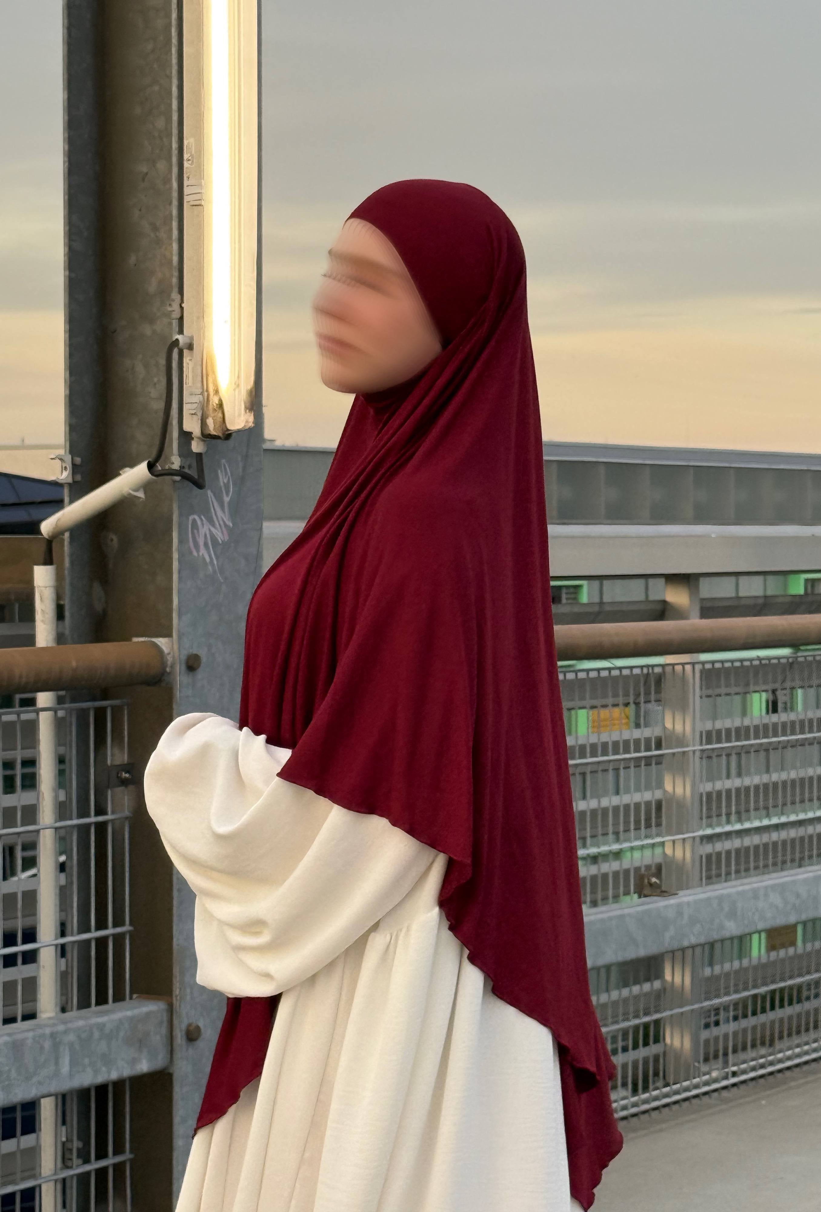 Ein bordeauxfarbener Jersey Khimar aus Viskose-Elastan in langer Ausführung ist in seitlicher Ansicht zu sehen.