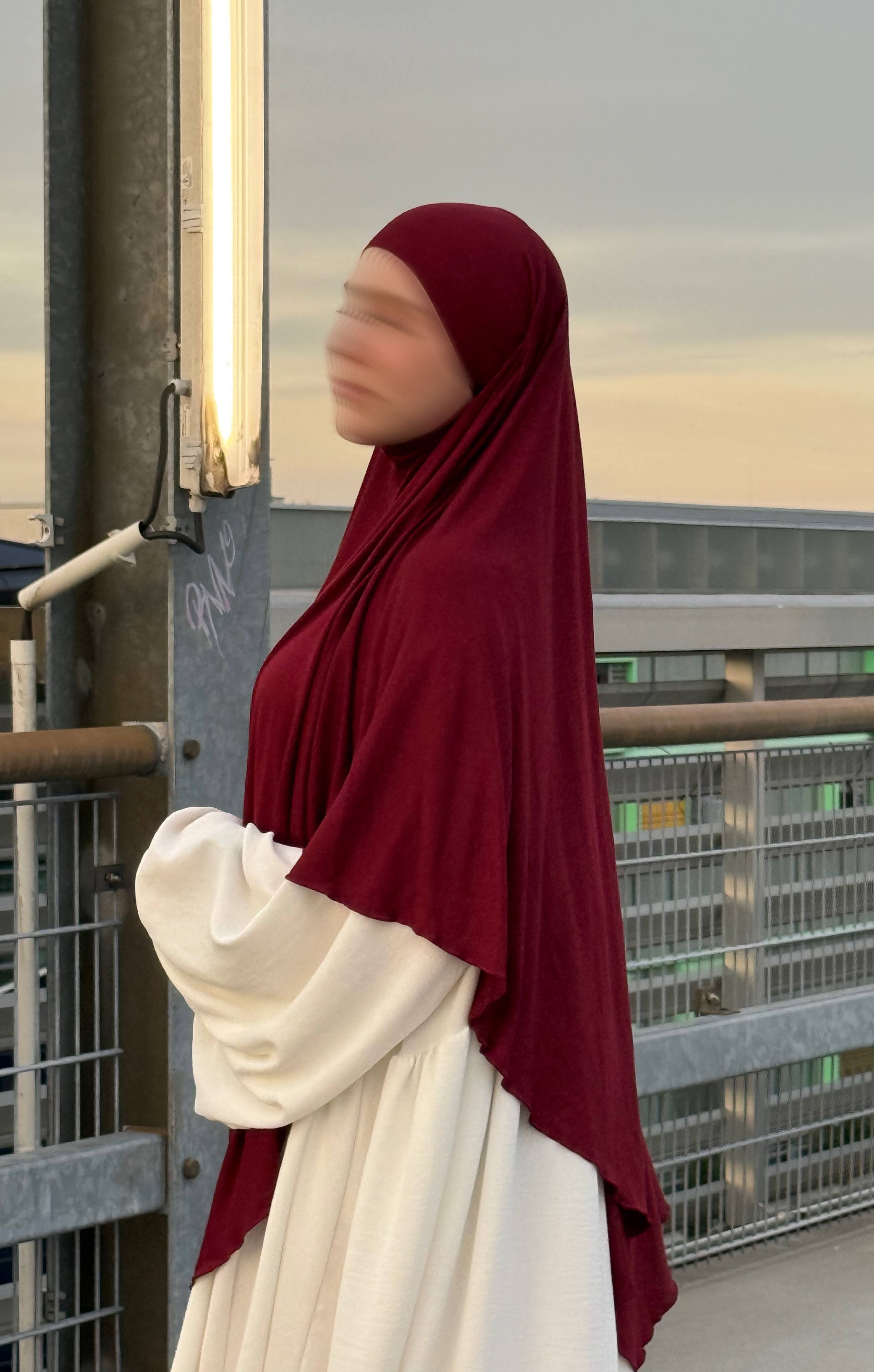 Ein bordeauxfarbener Jersey Khimar aus Viskose-Elastan in langer Ausführung ist in seitlicher Ansicht zu sehen.