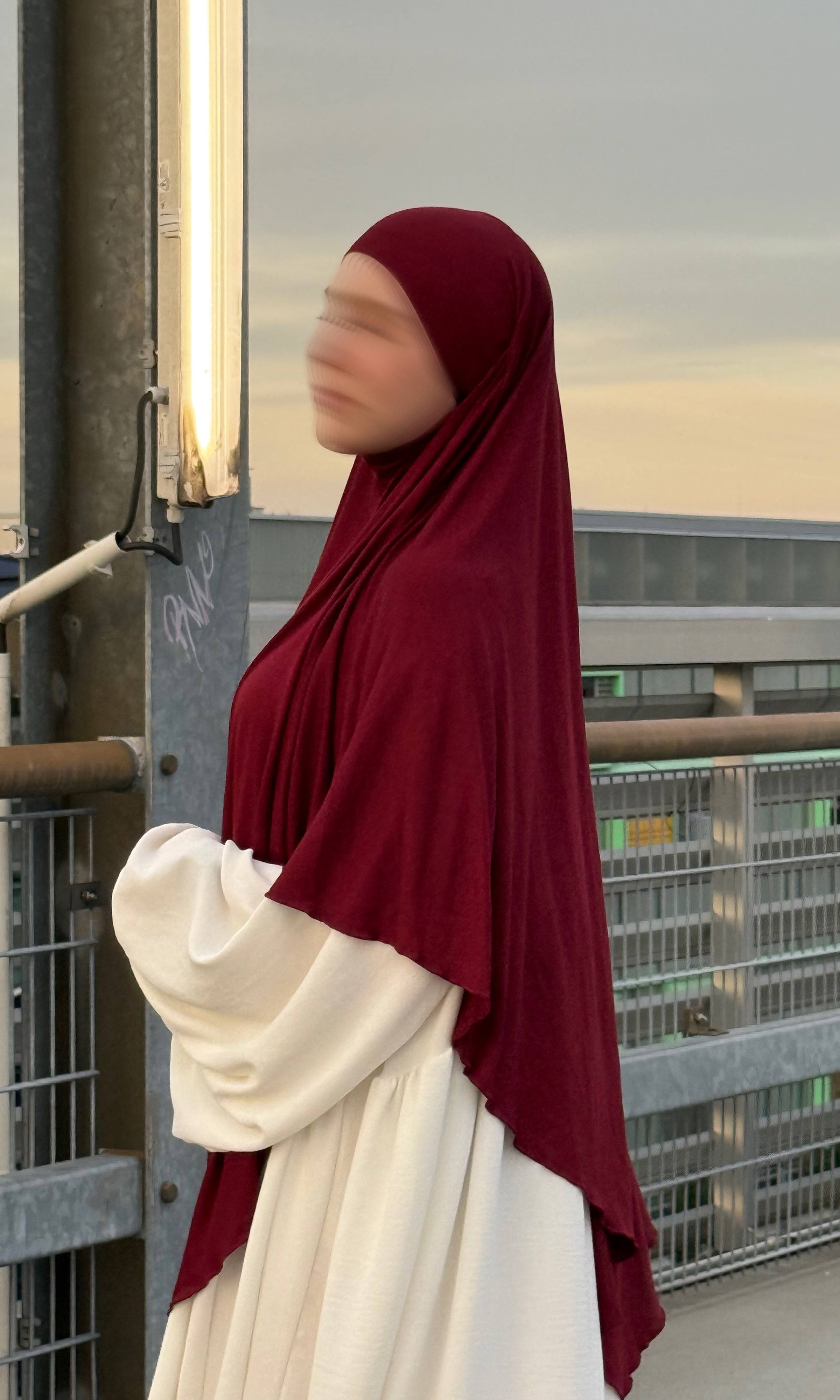 Ein bordeauxfarbener Jersey Khimar aus Viskose-Elastan in langer Ausführung ist in seitlicher Ansicht zu sehen.