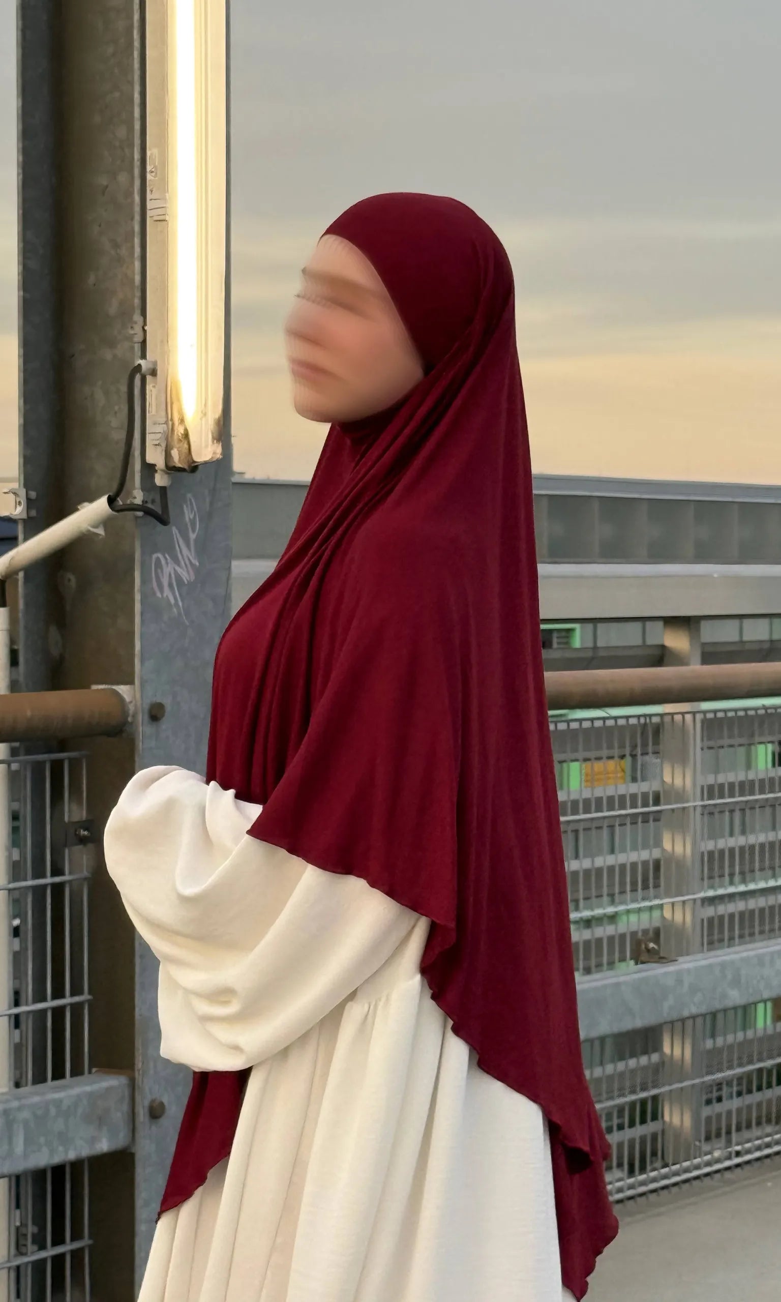 Ein bordeauxfarbener Jersey Khimar aus Viskose-Elastan in langer Ausführung ist in seitlicher Ansicht zu sehen.
