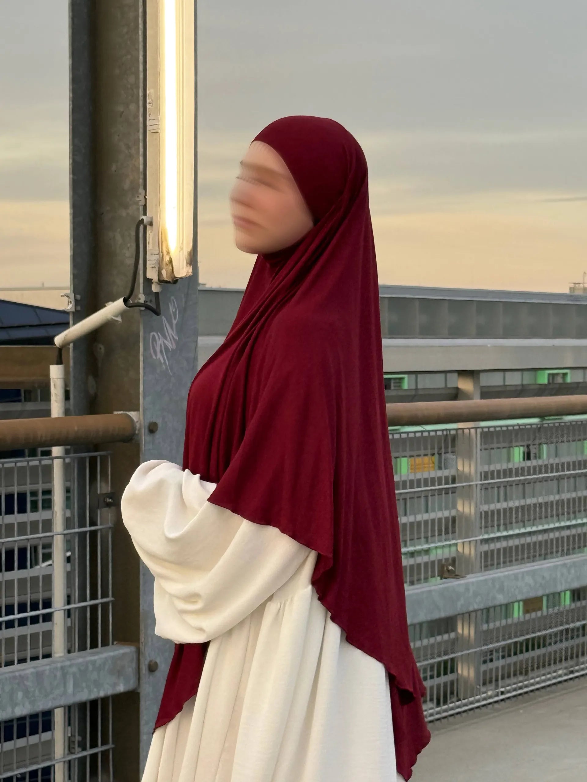 Ein bordeauxfarbener Jersey Khimar aus Viskose-Elastan in langer Ausführung ist in seitlicher Ansicht zu sehen.