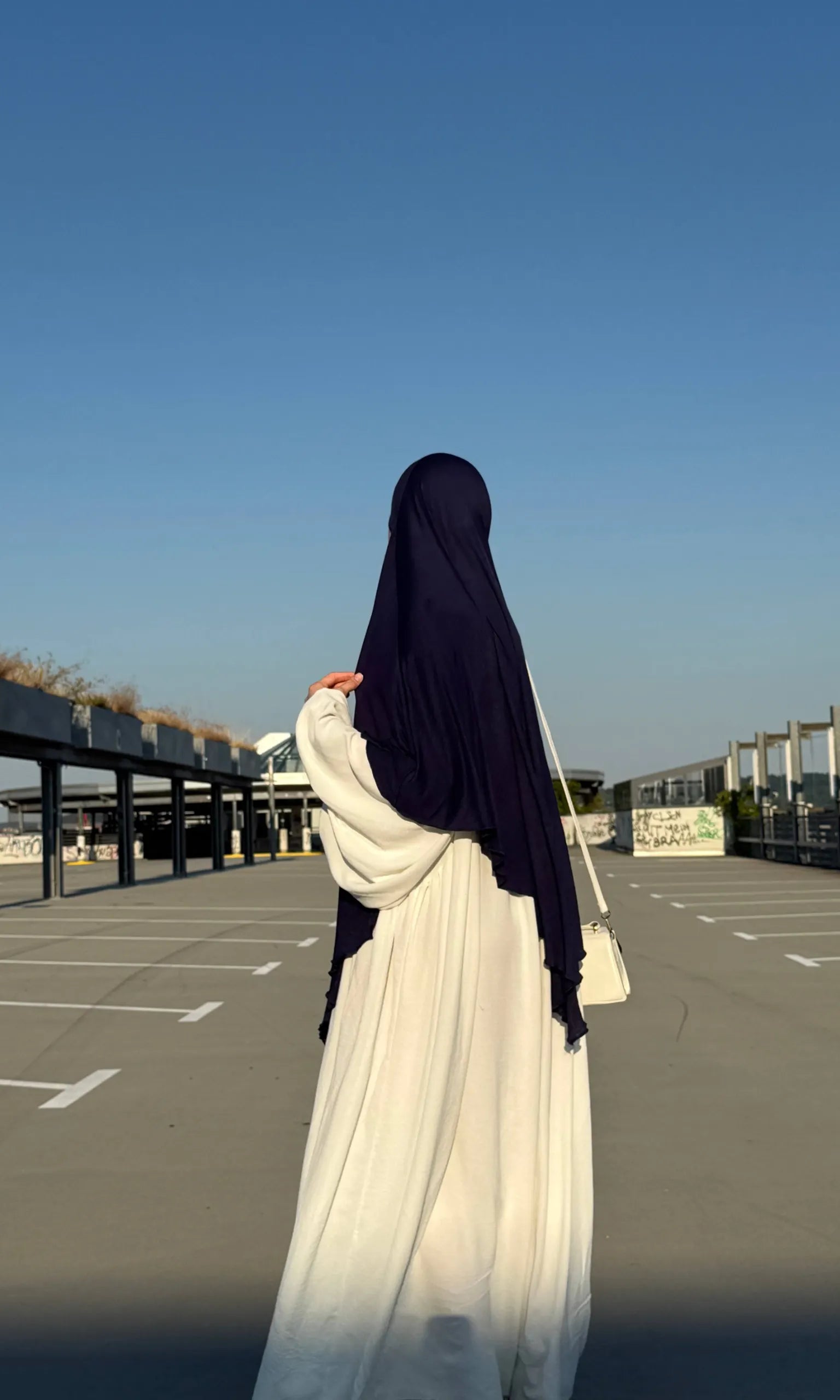 Der Jersey Khimar aus dunkelblauem Viskose‑Elastan‑Jersey ist in Rückenansicht dargestellt.