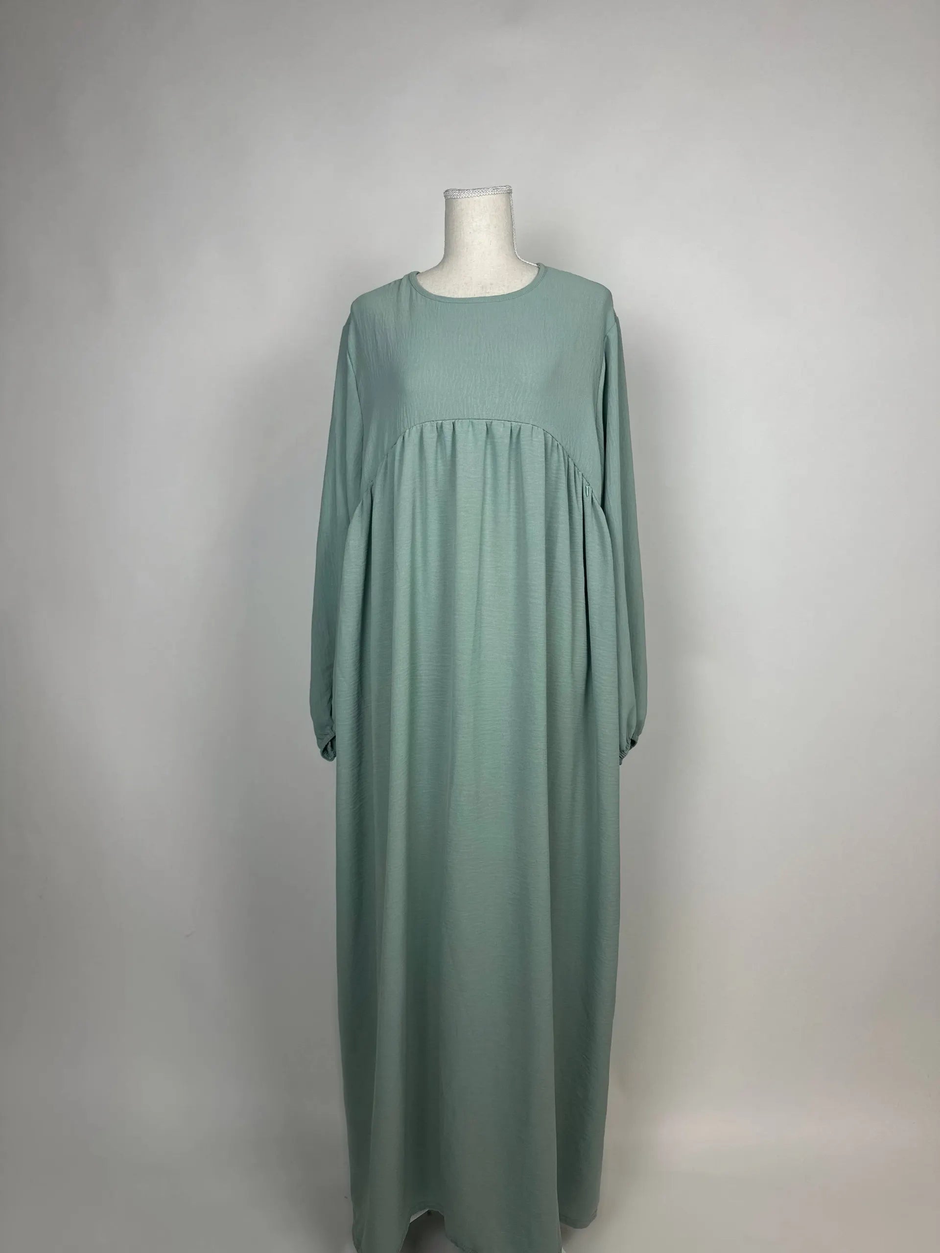 Salbeigrüne Abaya aus Jazzstoff mit Stillfunktion und hoher Empire-Naht, gezeigt in Vorderansicht