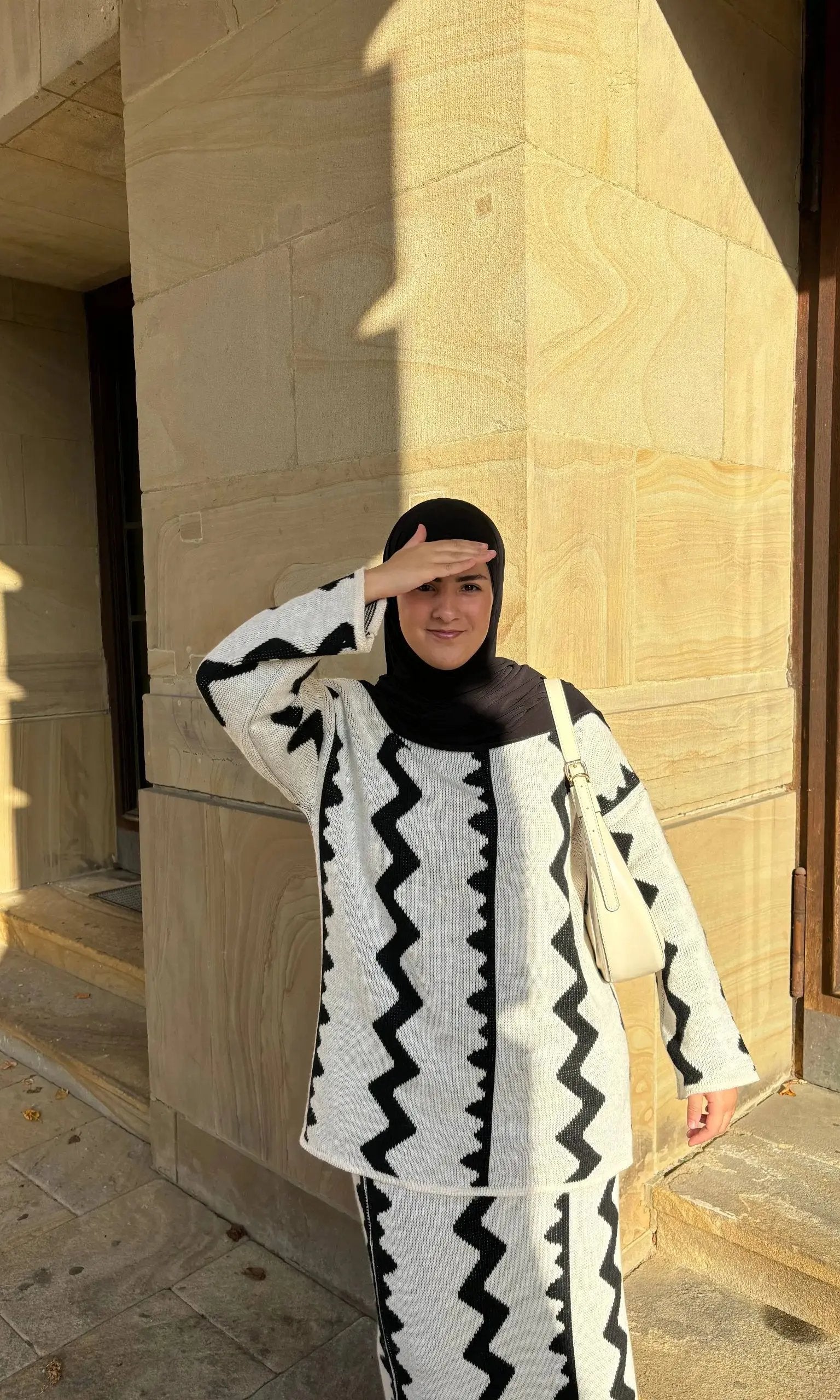 Hellgrauer Modest-Fashion Zweiteiler mit Rock aus Strick mit schwarzem Zickzackmuster, langarm, Vorderansicht