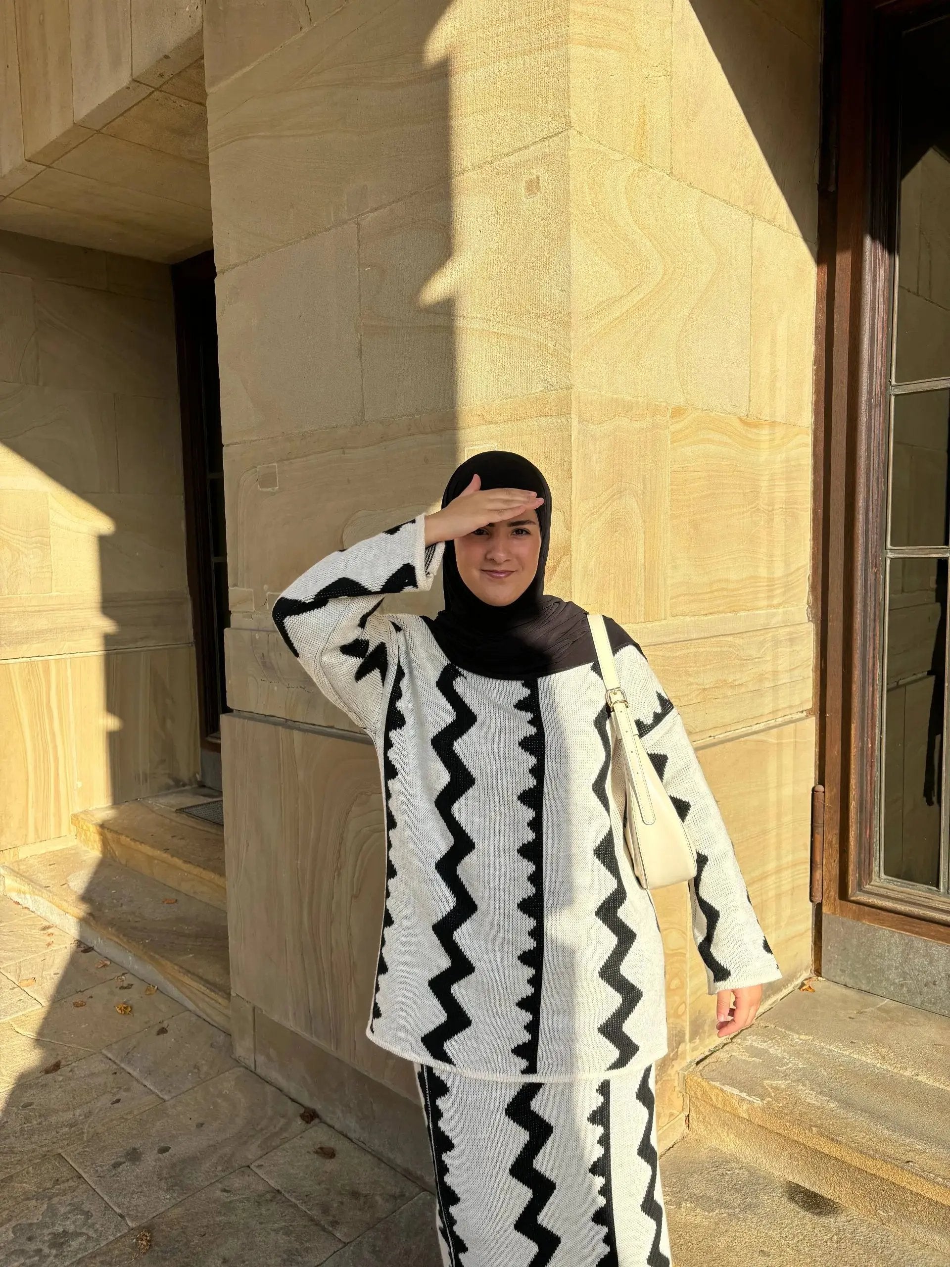 Hellgrauer Modest-Fashion Zweiteiler mit Rock aus Strick mit schwarzem Zickzackmuster, langarm, Vorderansicht