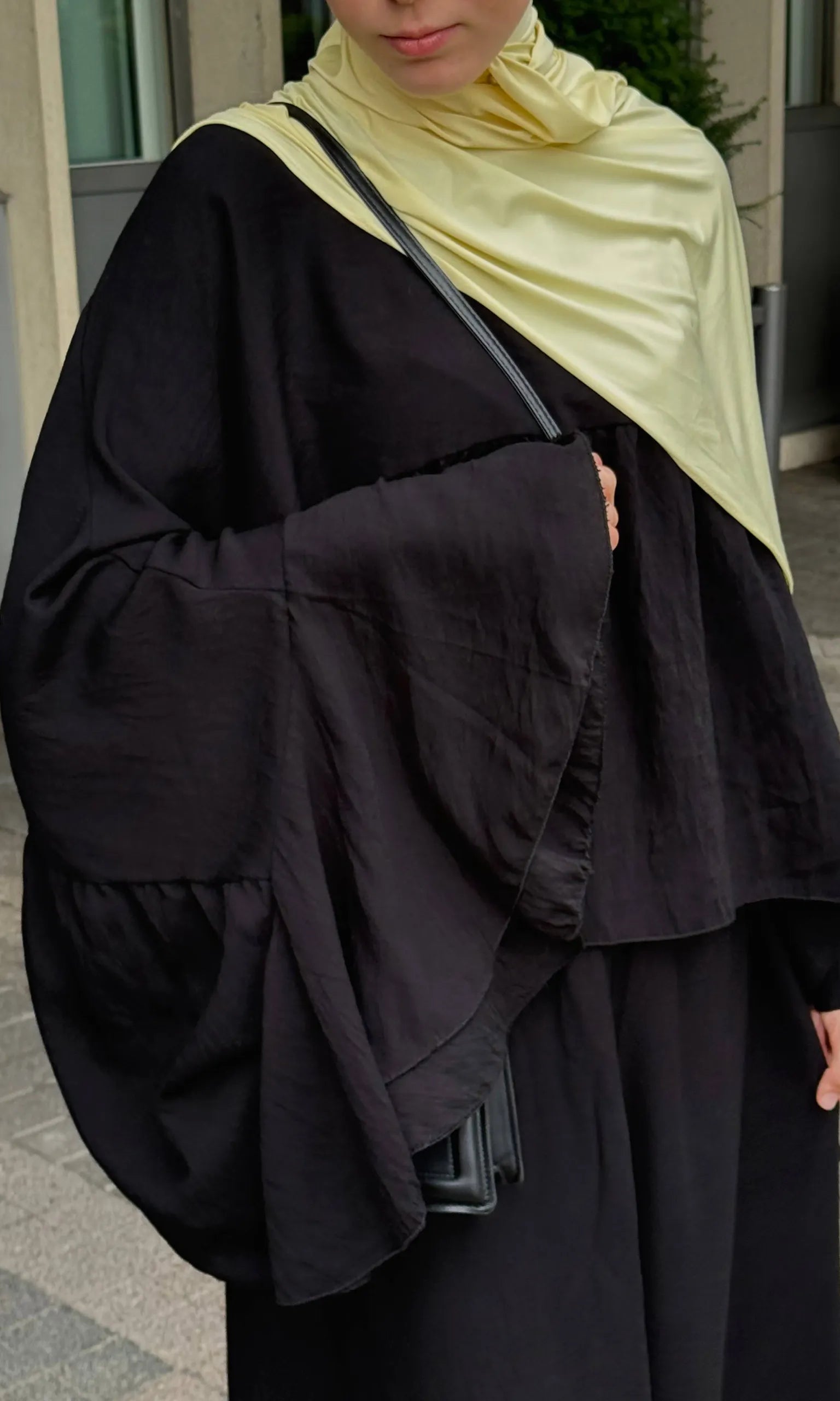 zweiteiler in schwarz mit fließendem top, weiten fledermausärmeln und maxirock, nahe frontansicht