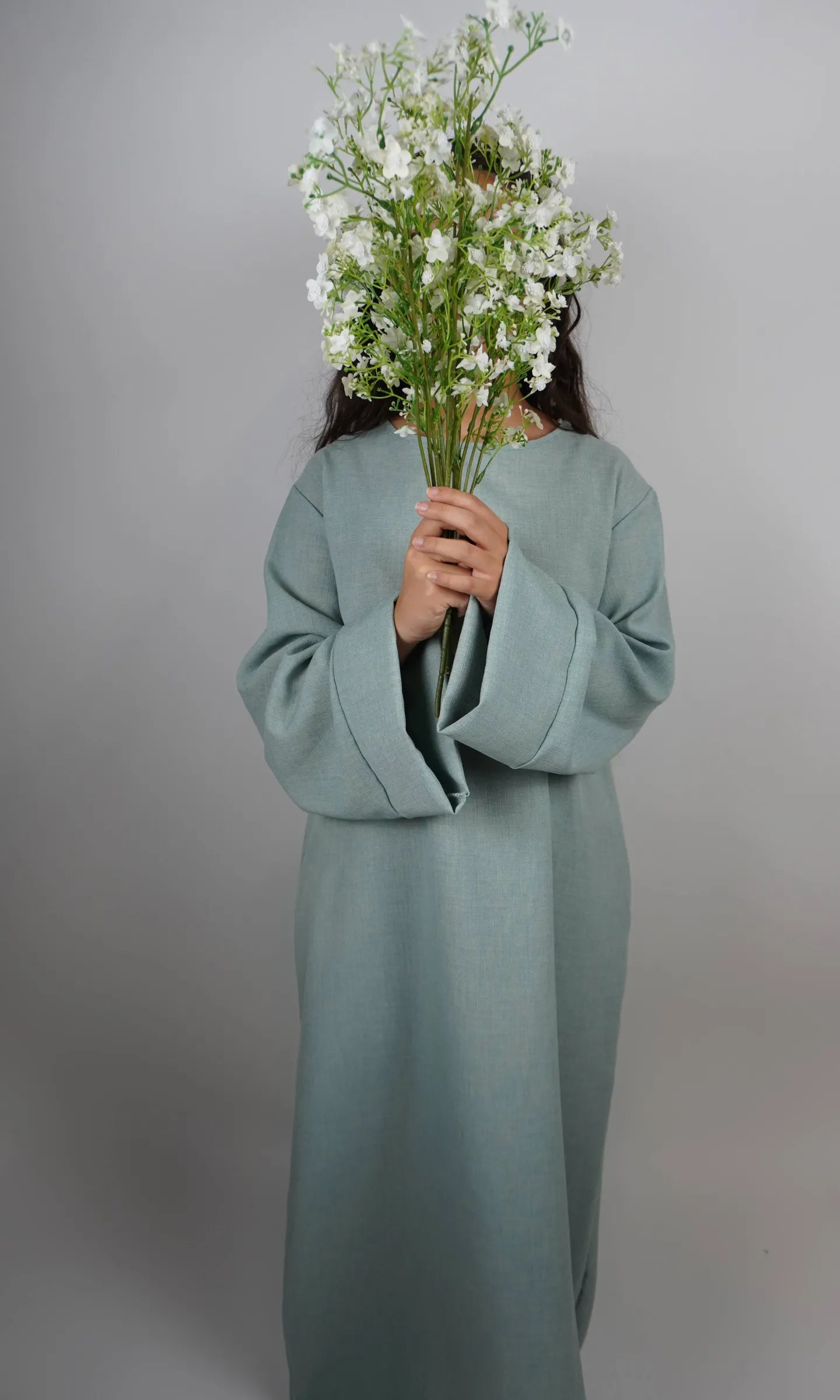 Diese schlichte sandfarbene Abaya in Leinenoptik ist knöchellang und in Frontansicht dargestellt.