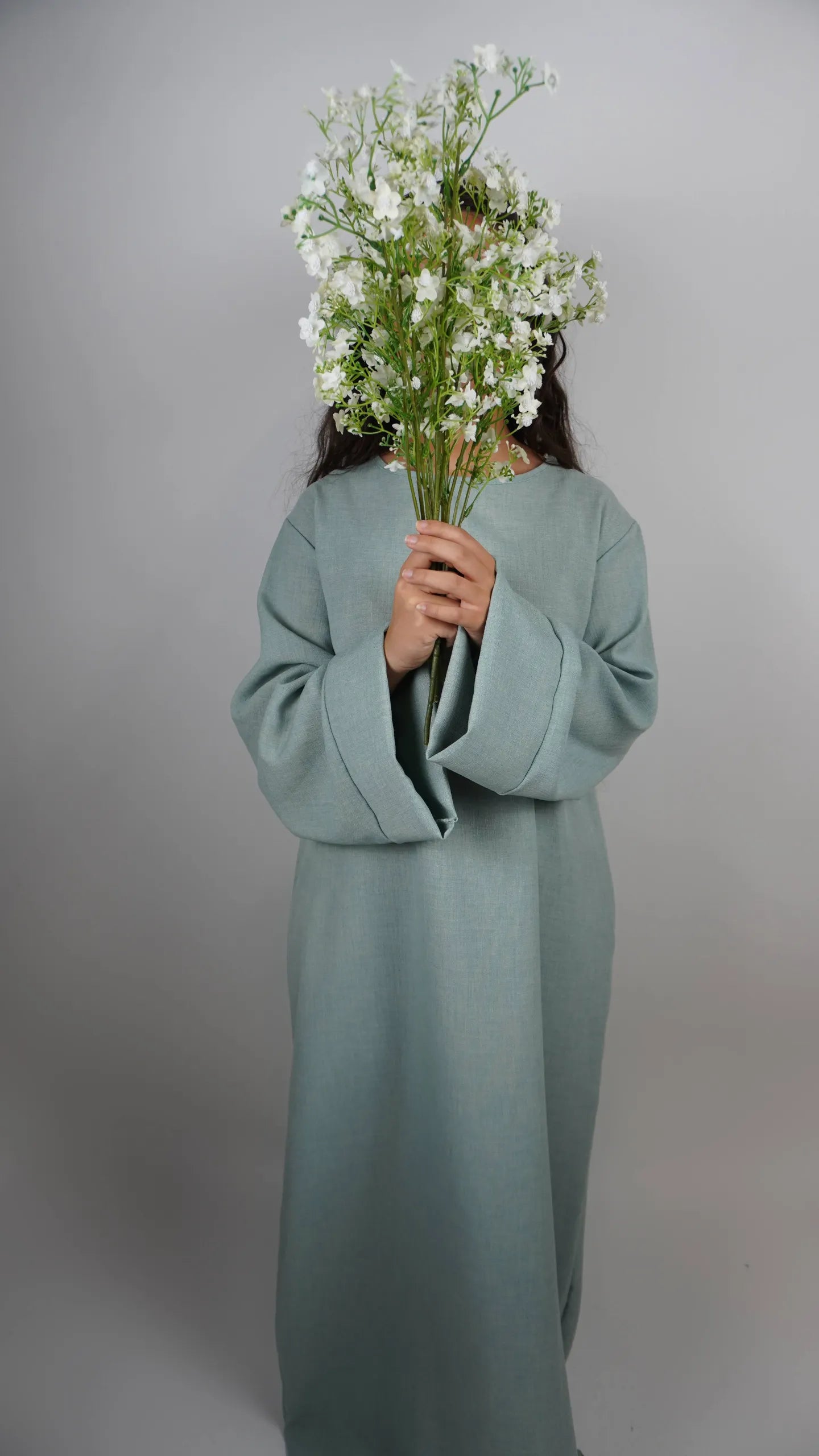 Diese schlichte sandfarbene Abaya in Leinenoptik ist knöchellang und in Frontansicht dargestellt.