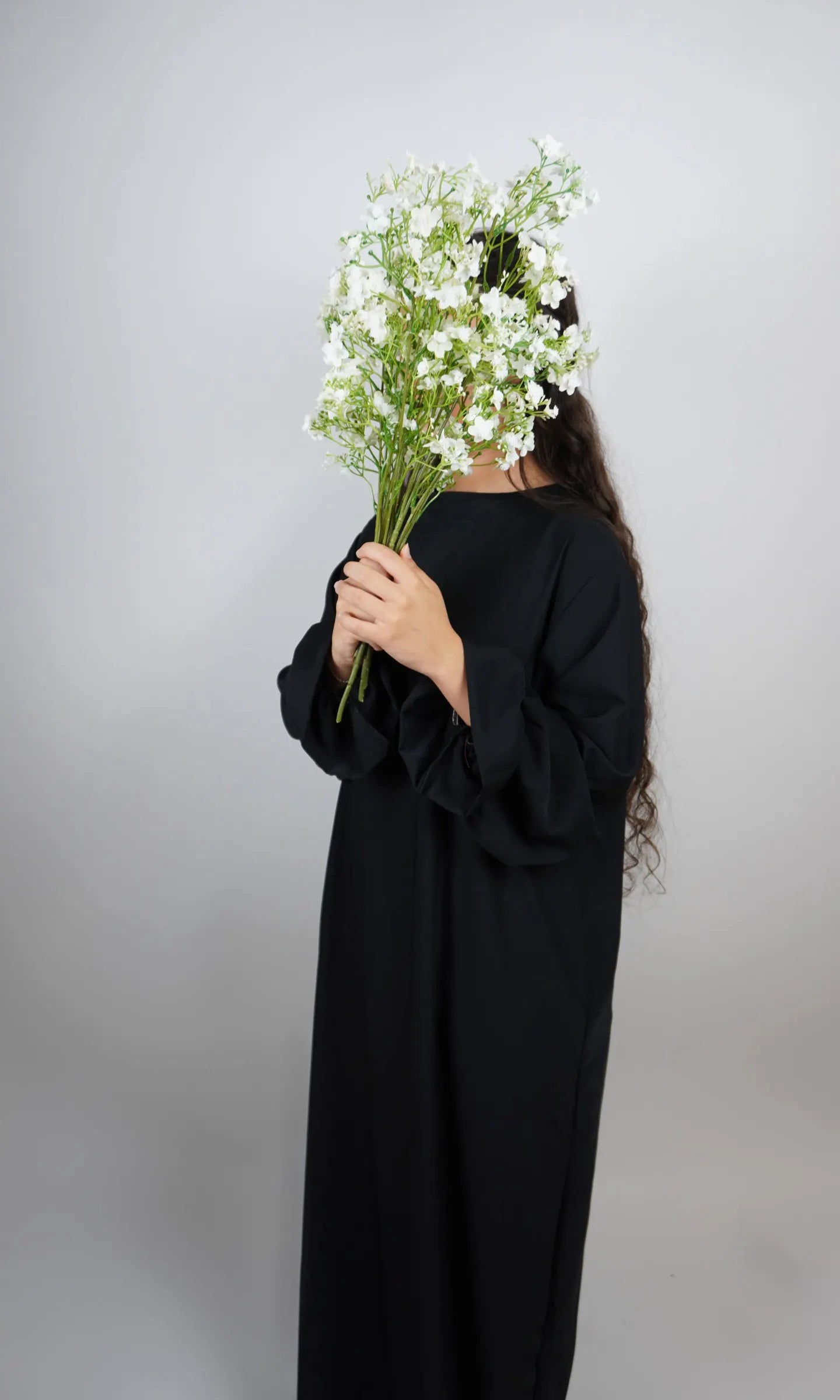 Schwarze Abaya aus Medina-Seide mit Rüschenärmeln, Frontansicht.