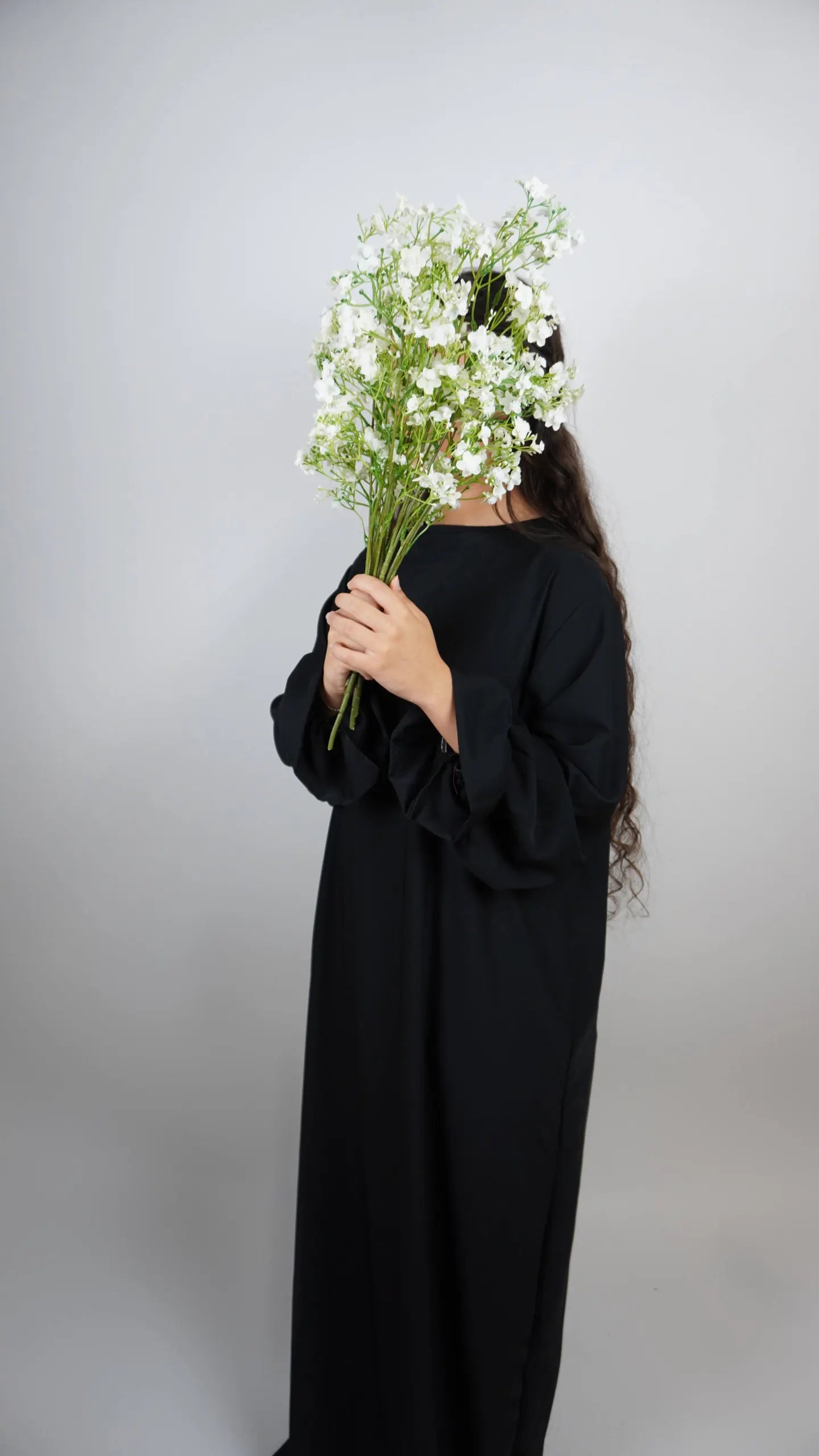 Schwarze Abaya aus Medina-Seide mit Rüschenärmeln, Frontansicht.