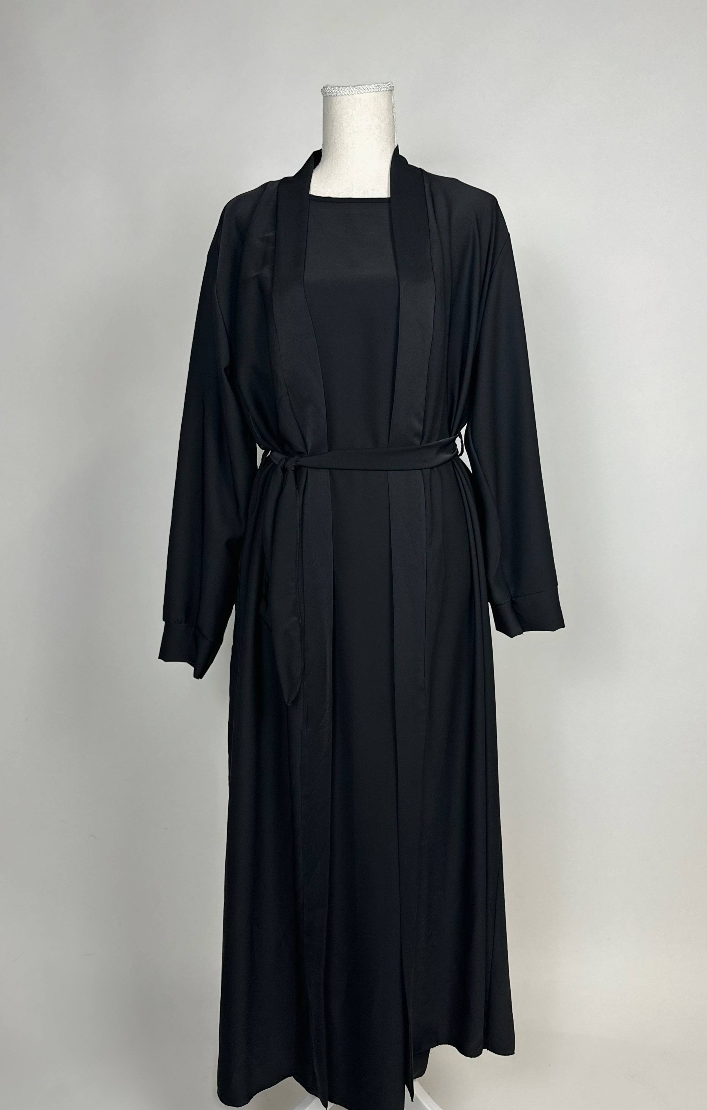Schwarze Open-Abaya aus fließendem Stoff mit Unterkleid und Bindegürtel, Vorderansicht.