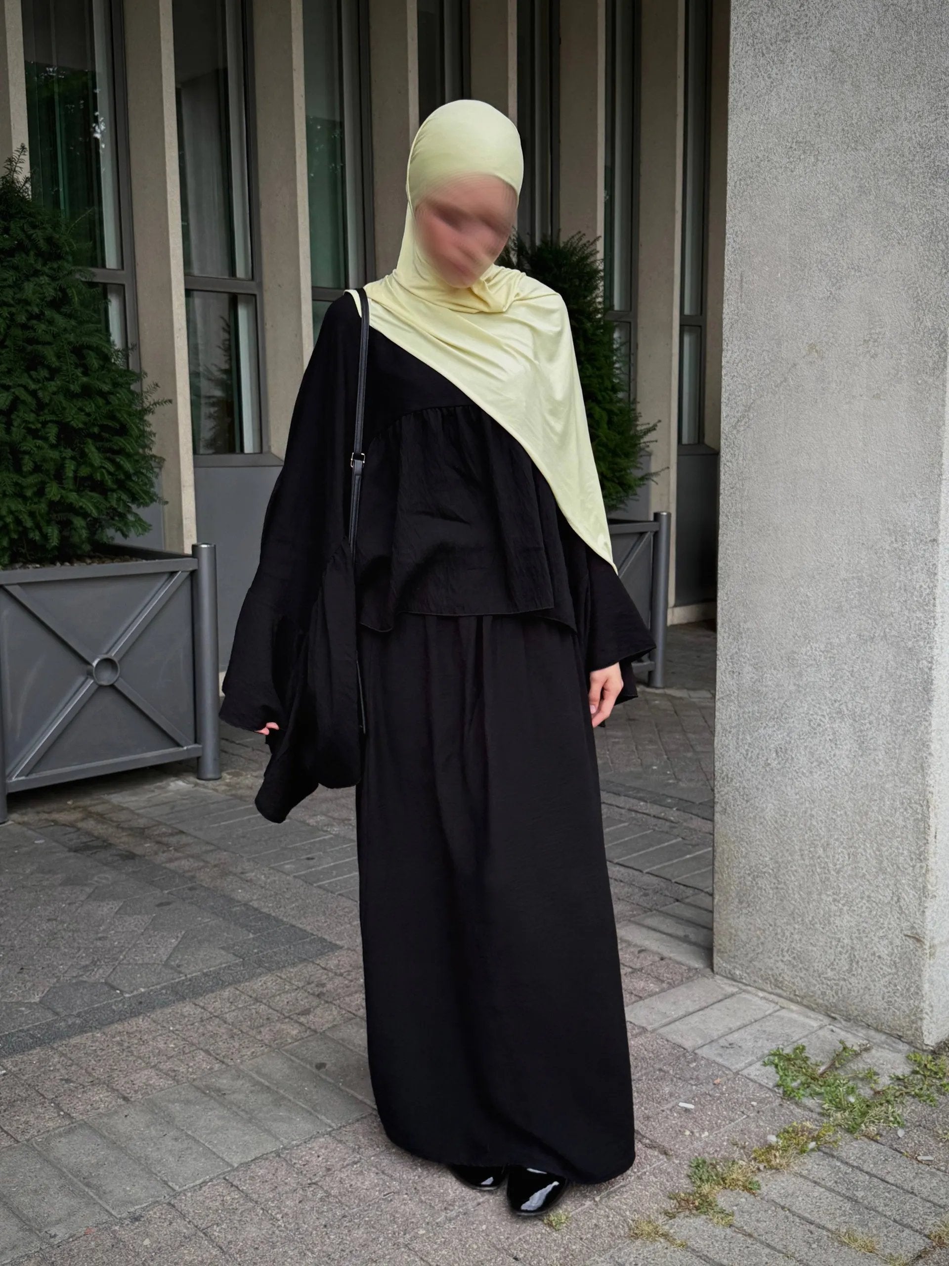 zweiteiler in schwarz, lockeres oberteil mit weiten ärmeln und maxirock, frontansicht