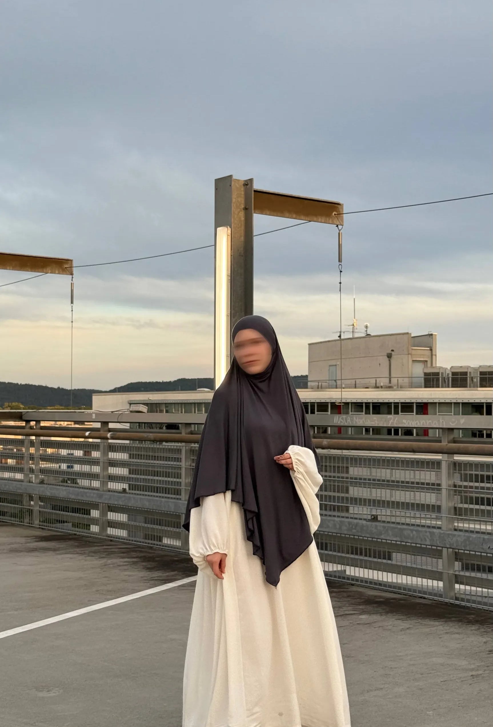 Eine stehende Person trägt einen dunkelgrauen Jersey Khimar (Viskose/Elastan) in Frontalansicht.