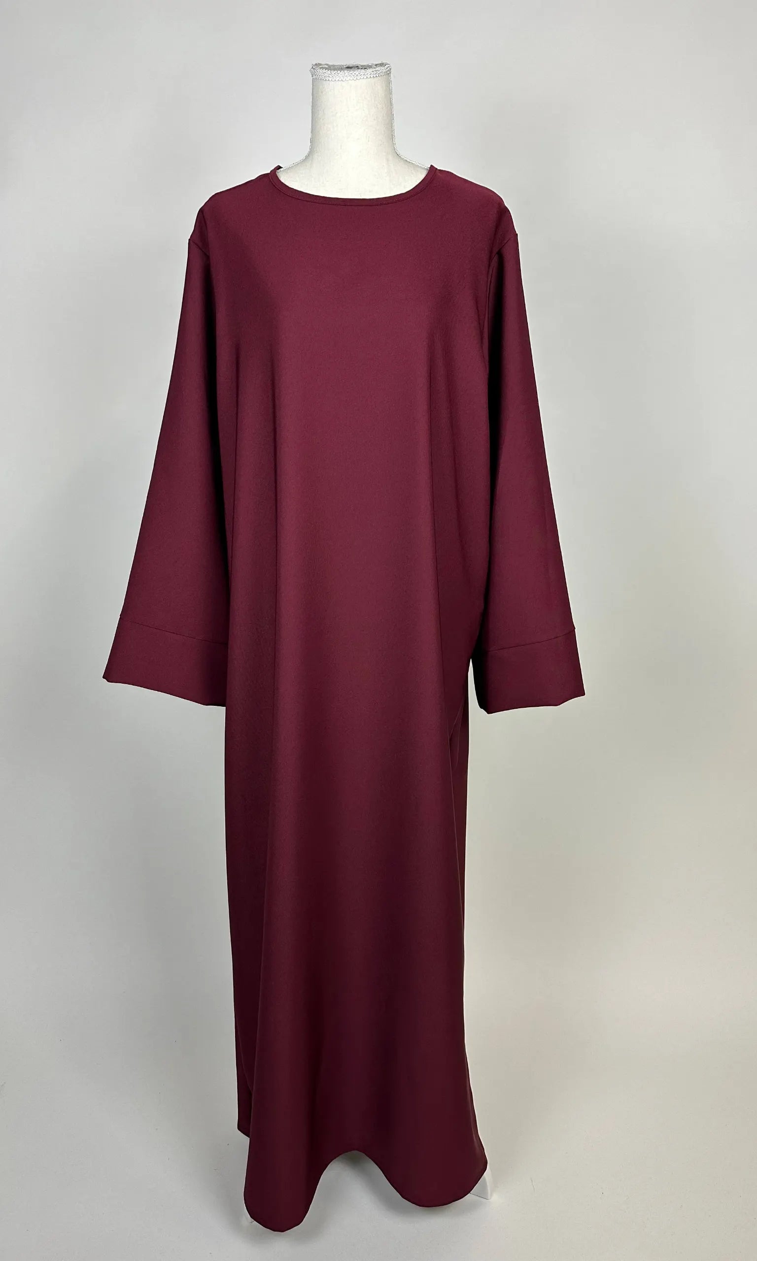 bordeauxrote lange abaya aus polyester mit weiten ärmeln und rundhalsausschnitt, vorderansicht auf schaufensterpuppe