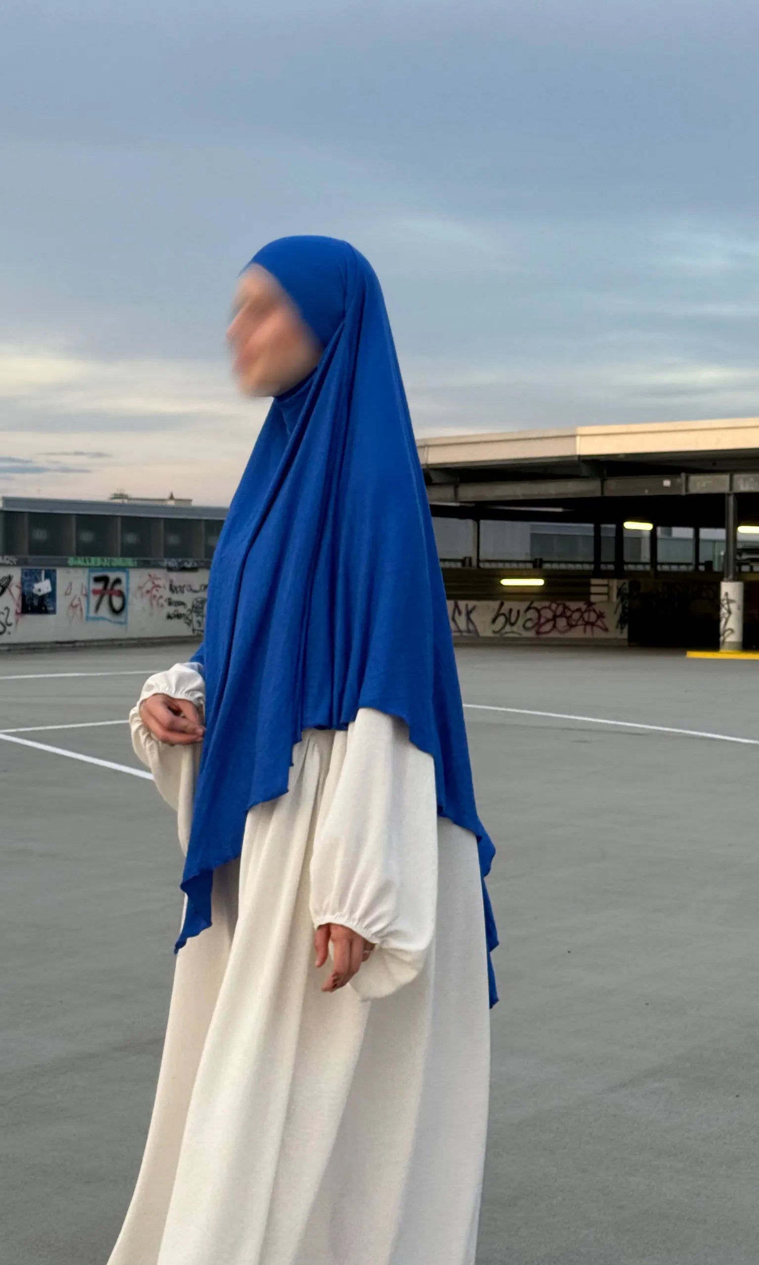 Blauer Jersey-Khimar aus Viskose-Elastan in seitlicher Ganzkörperansicht über weißem Kleid.