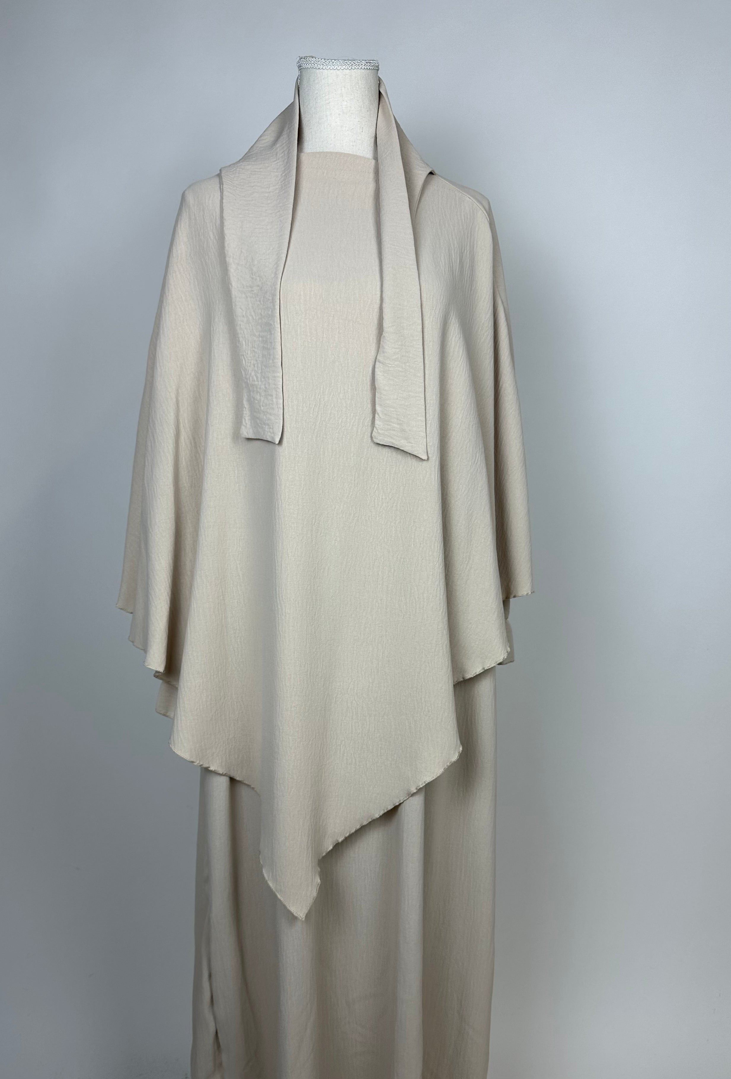 beiges set aus abaya und khimar, strukturierter stoff, asymmetrischer saum, frontansicht