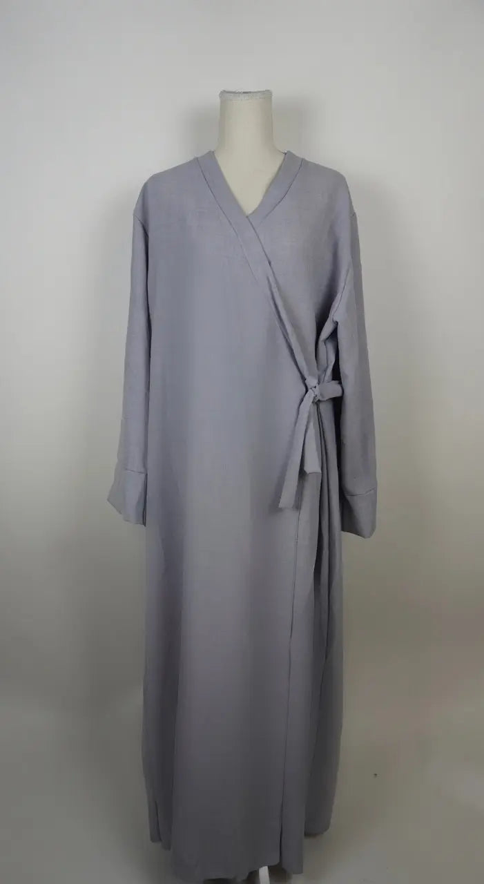 Graue Wickelabaya in Leinenoptik mit seitlicher Schleife wird in der Vorderansicht gezeigt, Modest Hijab Fashion