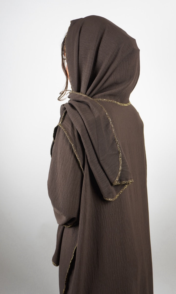 Braune Einteiler-Abaya aus Crinkle-Stoff mit integriertem Hijab und goldener Kantenverzierung, Rückansicht.