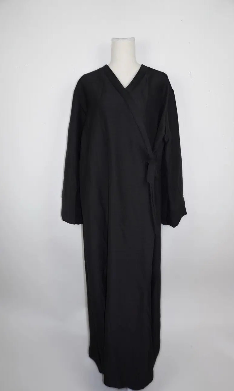 Schwarze Wickelabaya in Leinenoptik mit seitlicher Schleife und langen Ärmeln, Modest Hijab Style, Vorderansicht.