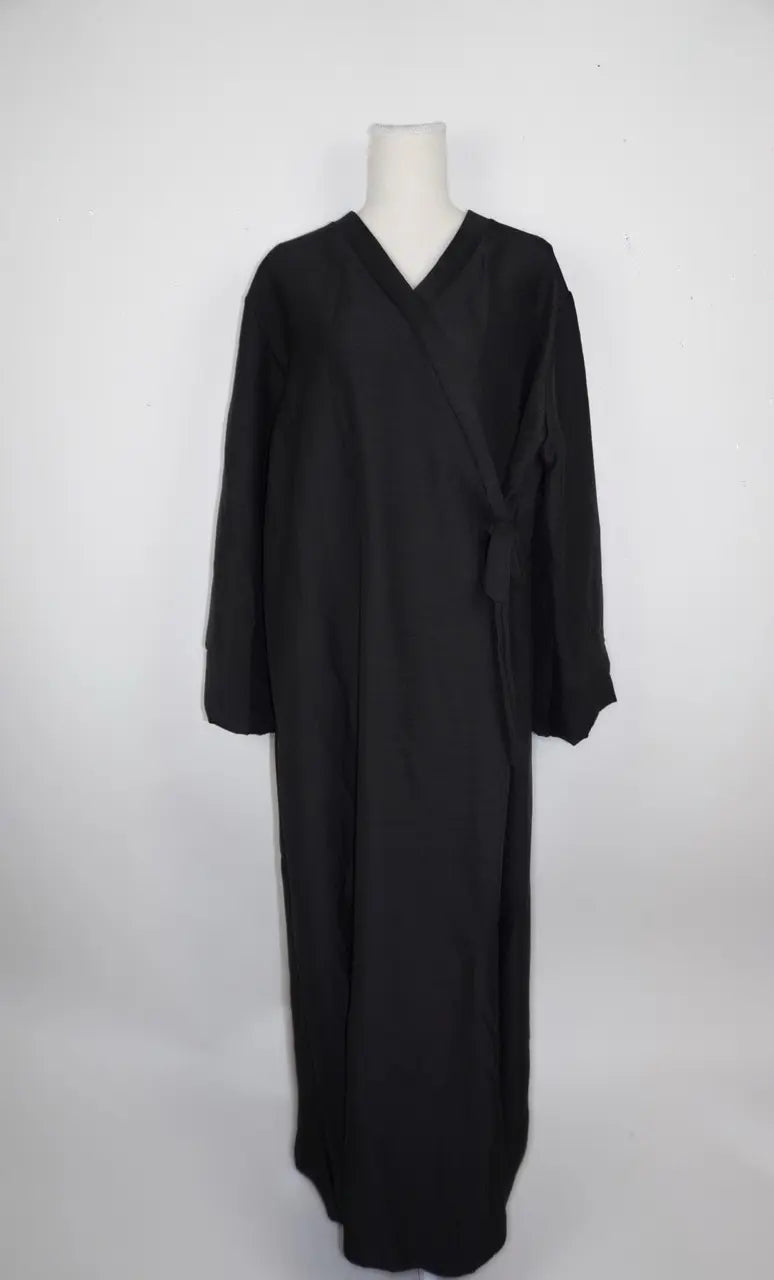 Schwarze Wickelabaya in Leinenoptik mit seitlicher Schleife und langen Ärmeln, Modest Hijab Style, Vorderansicht.