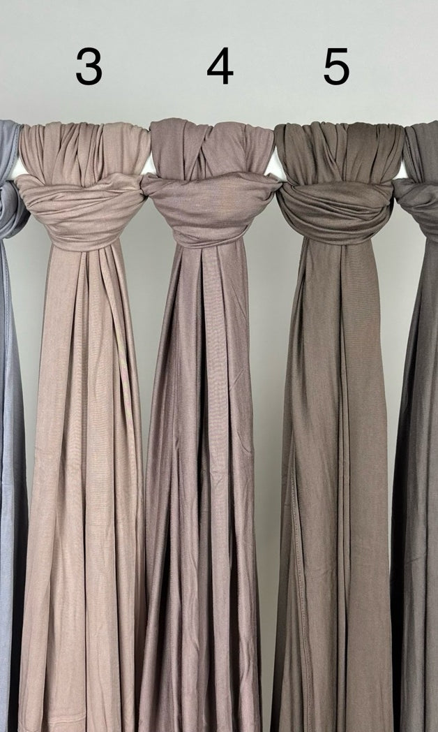 Neutrale Hijabs aus Jersey für Modest Abaya sind geknotet und mit Zahlen auf Stange, Vorderansicht