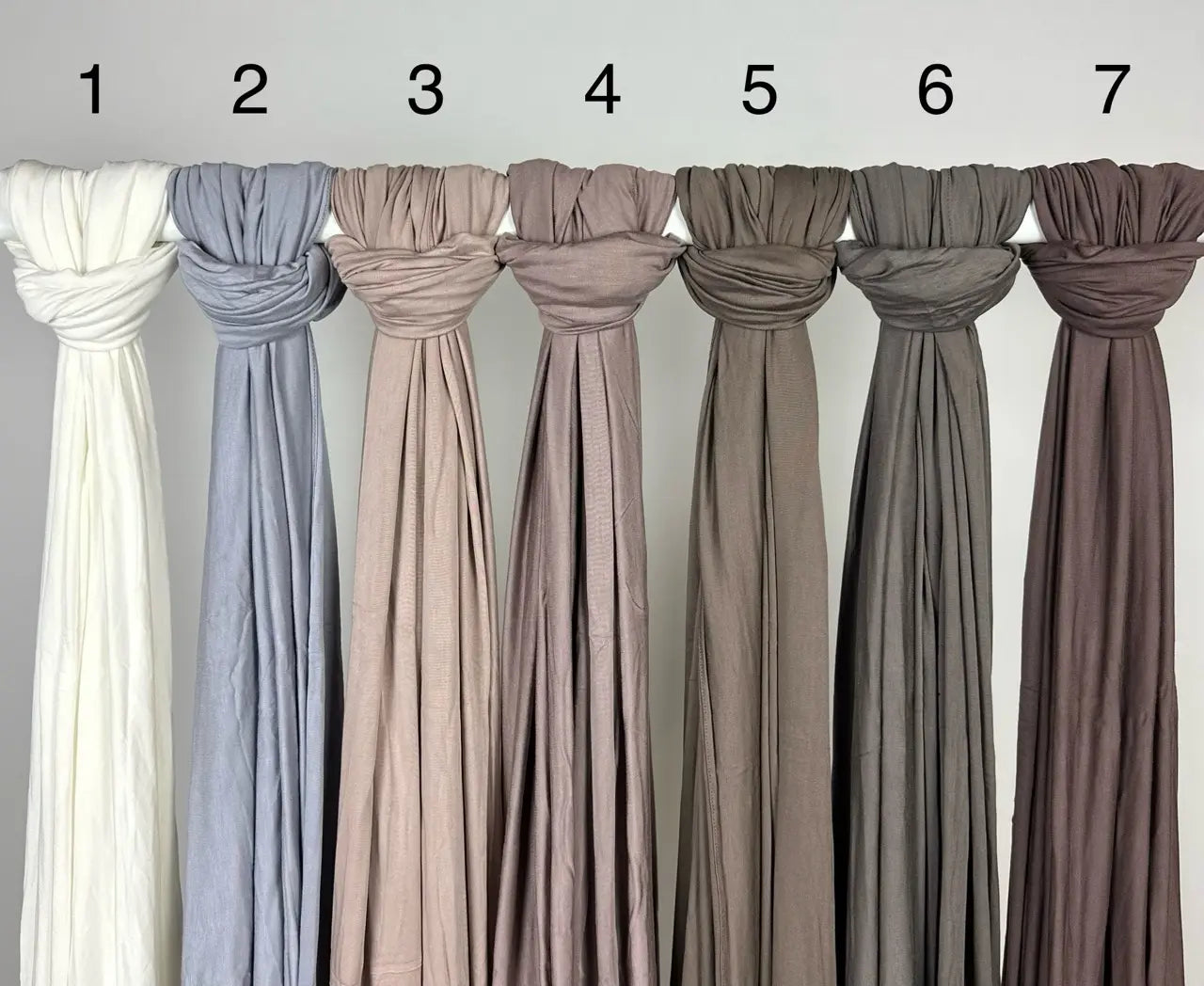 Neutrale Hijabs aus Jersey für Modest Abaya sind geknotet und mit Zahlen auf Stange, Vorderansicht
