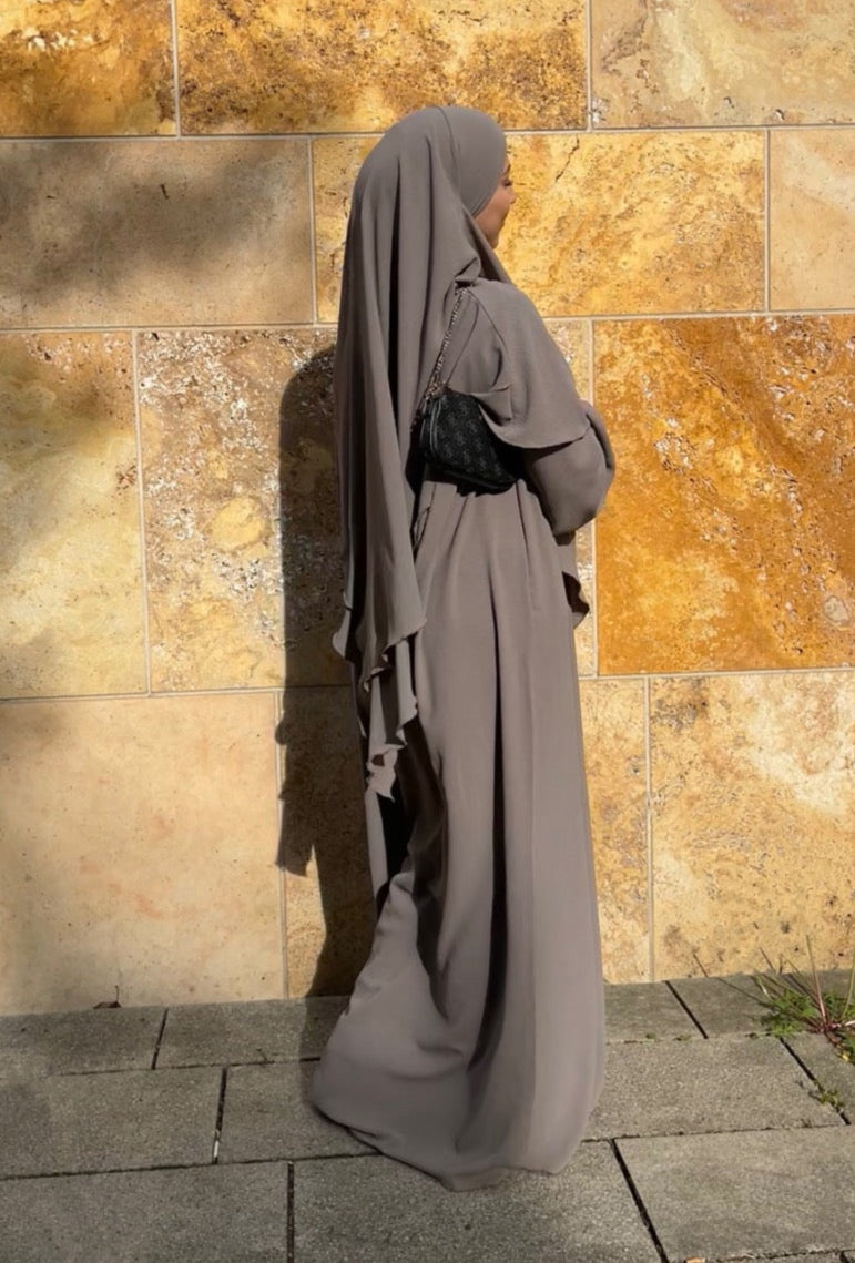 Ein zweilagiger Khimar und eine Abaya mit Ballonärmeln, frontale Ansicht, aus fließendem Material.