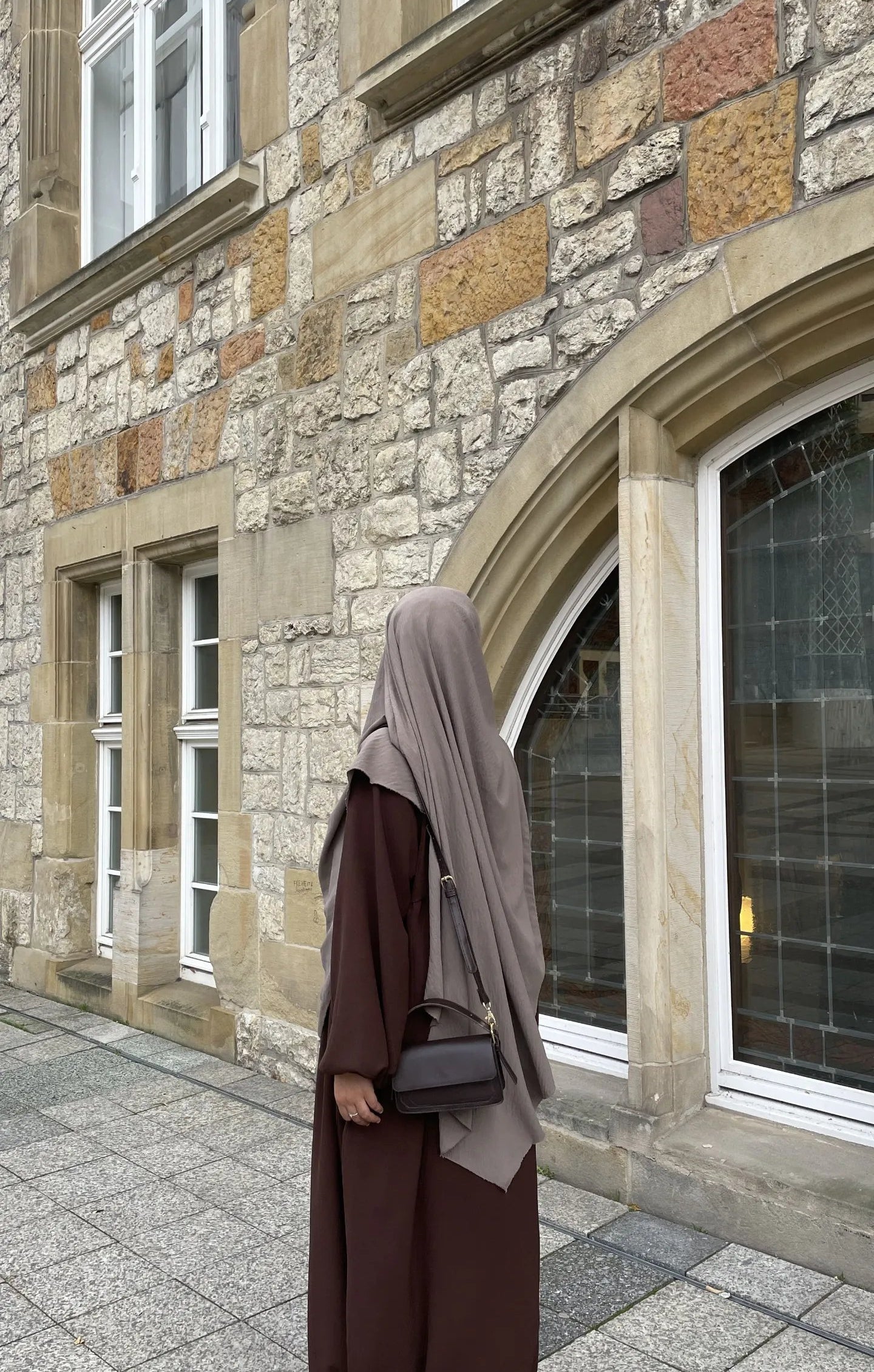 Eine braune Still-Abaya aus leichtem Jazzstoff mit Ballonärmeln ist in Frontansicht zu sehen.