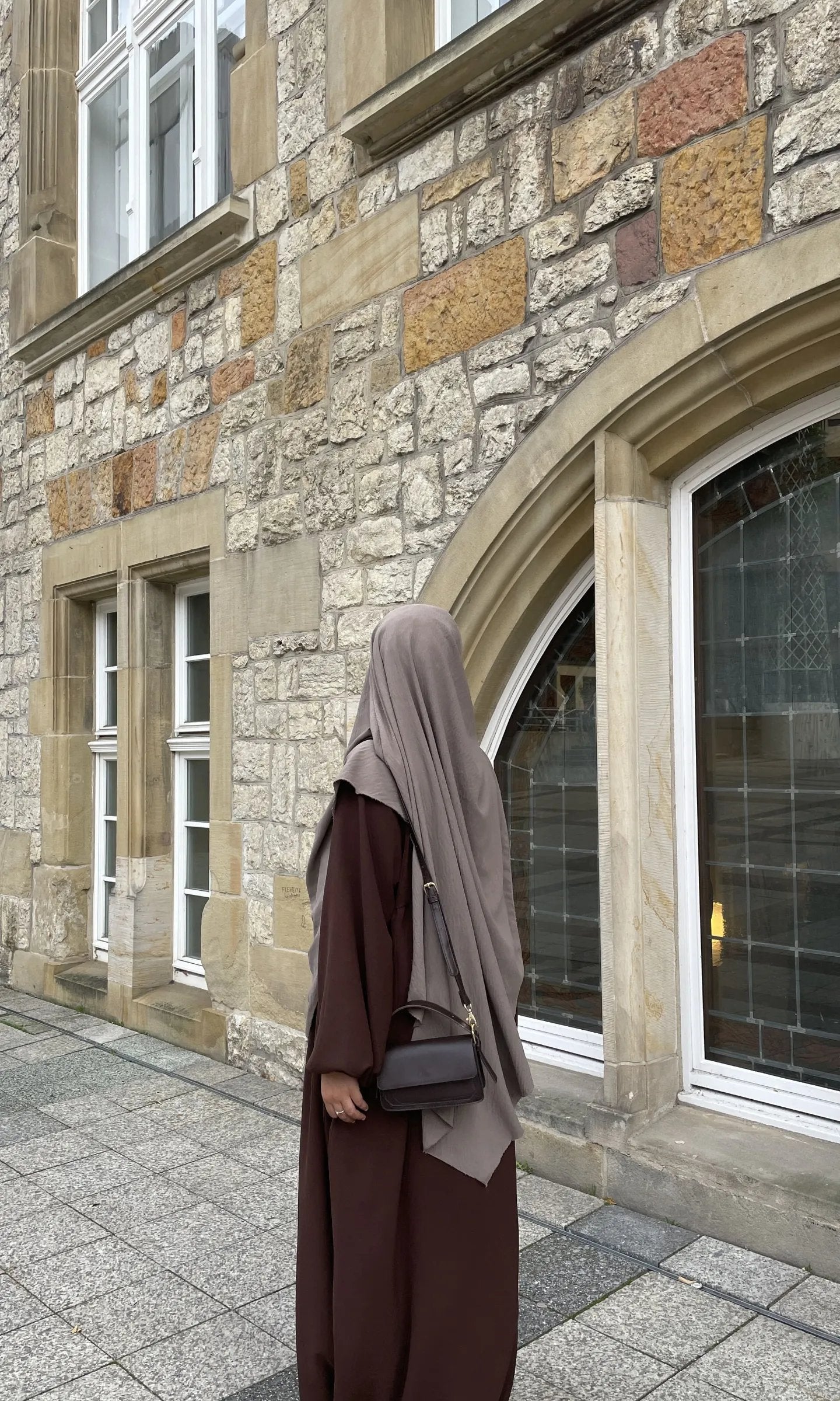 Eine braune Still-Abaya aus leichtem Jazzstoff mit Ballonärmeln ist in Frontansicht zu sehen.