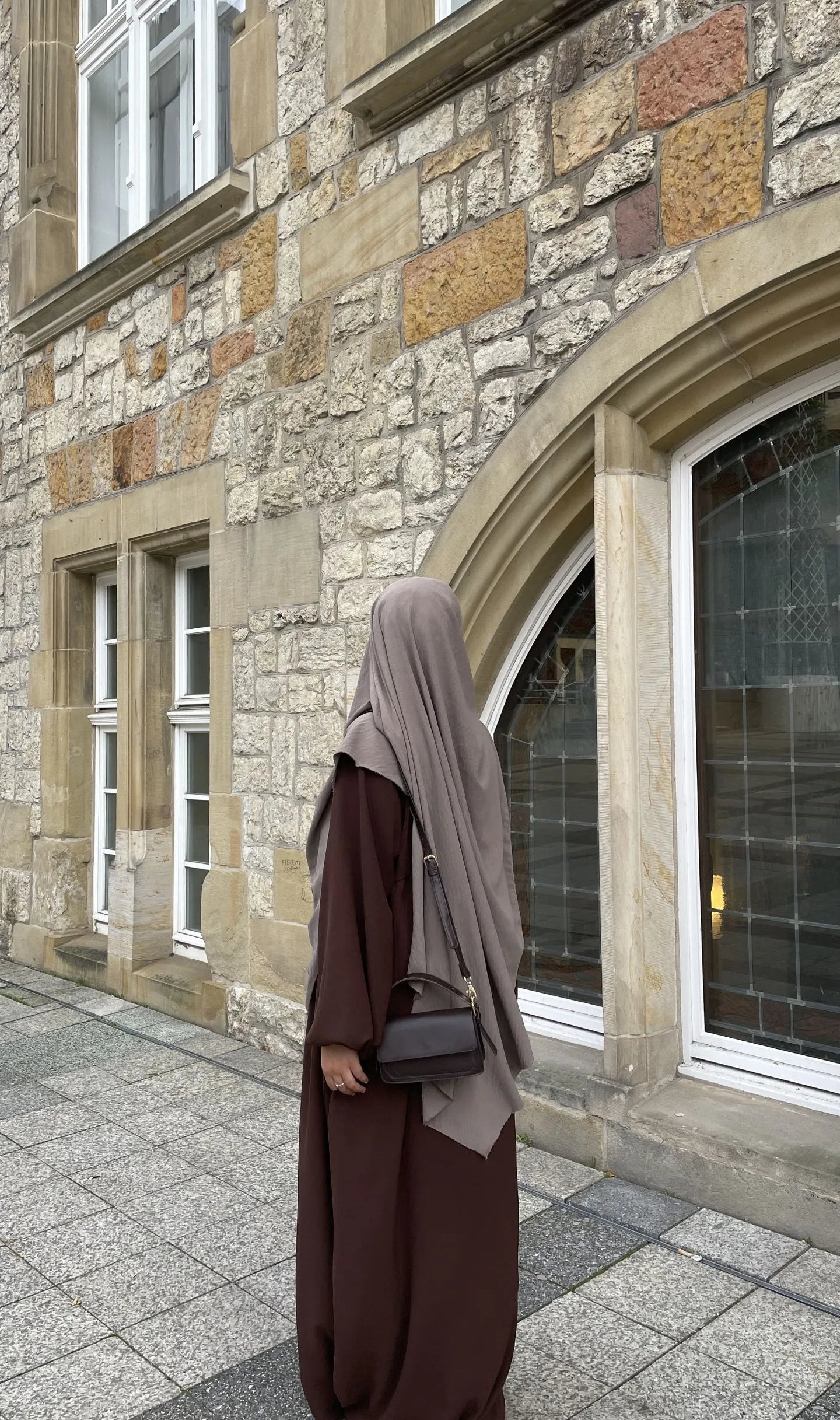 Eine braune Still-Abaya aus leichtem Jazzstoff mit Ballonärmeln ist in Frontansicht zu sehen.