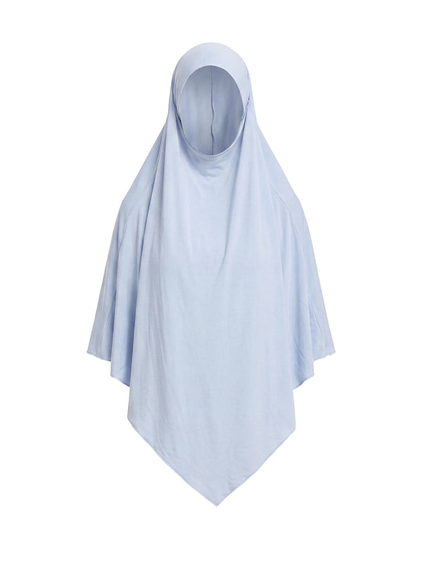 Unser langer Khimar in der Farbe Taupe, getragen von einem Model vor einer Wand mit dekorativen Blumen. Die fließende Silhouette des Khimar wird von der Seite gezeigt.