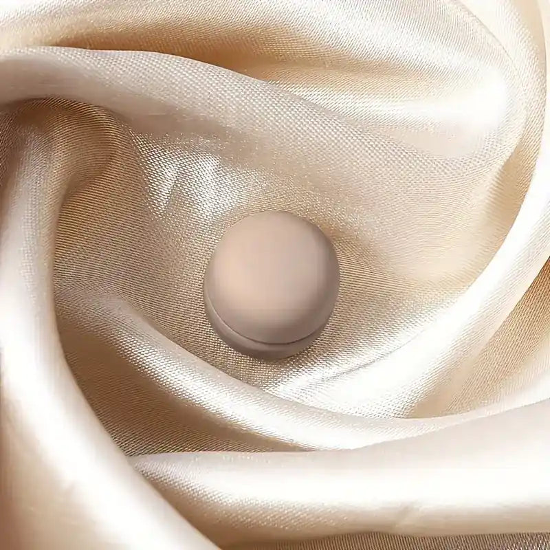 Beiger Hijab-Magnet, matt und rund, nadellos für starken Halt, auf champagnerfarbenem Satin-Hijab, Nahaufnahme