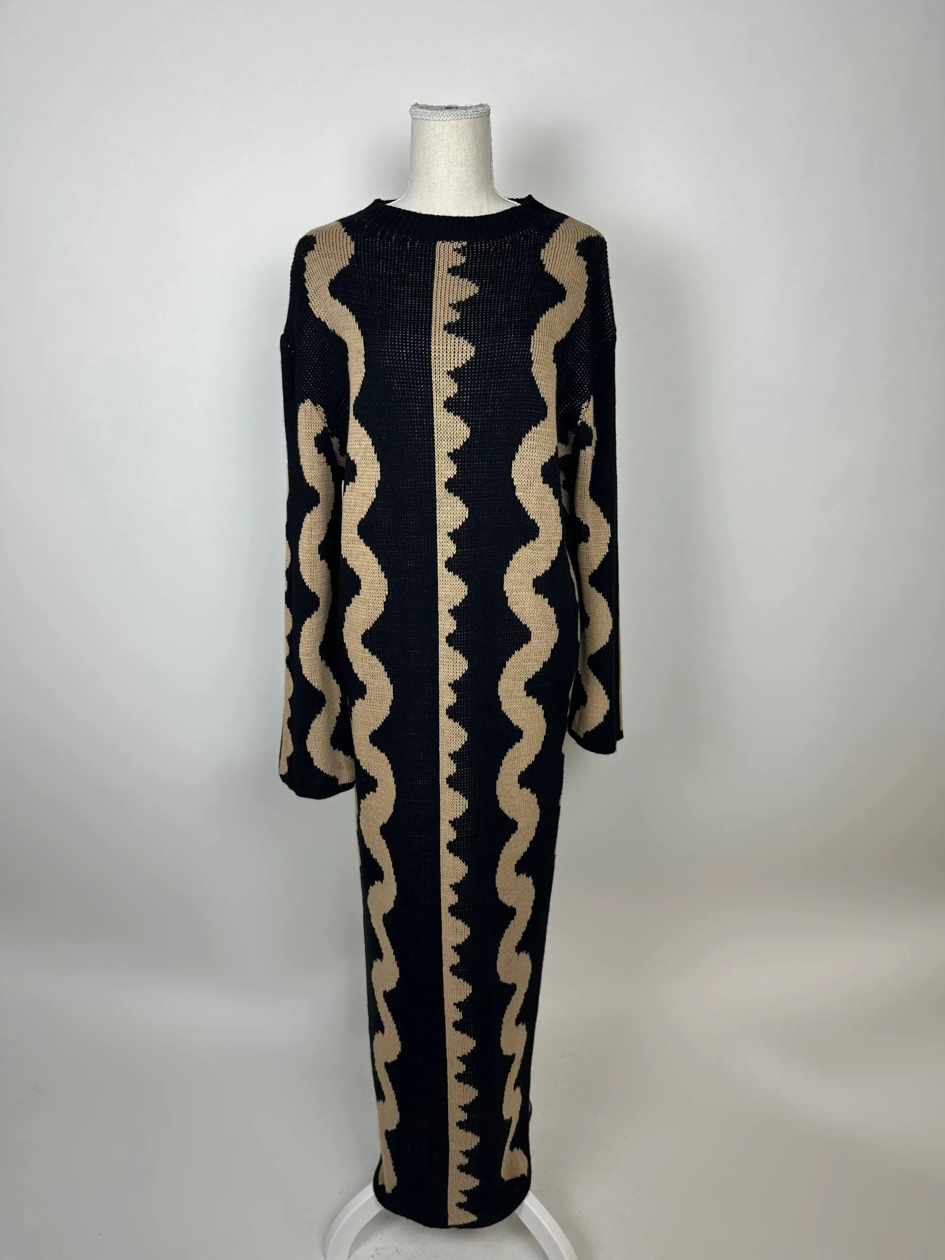Schwarz-beiges Maxi Strickkleid aus Strick mit vertikalem Wellenmuster und langen Ärmeln, Vorderansicht auf Puppe