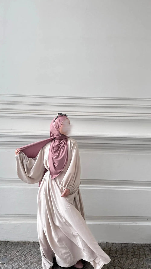 cremefarbene abaya aus jazz-stoff, bodenlang mit weiten ballonärmeln und schwingendem saum, seitliche ansicht