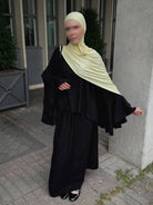 zweiteiler in schwarz mit weit schwingendem oberteil und fledermausärmeln, maxirock, frontansicht