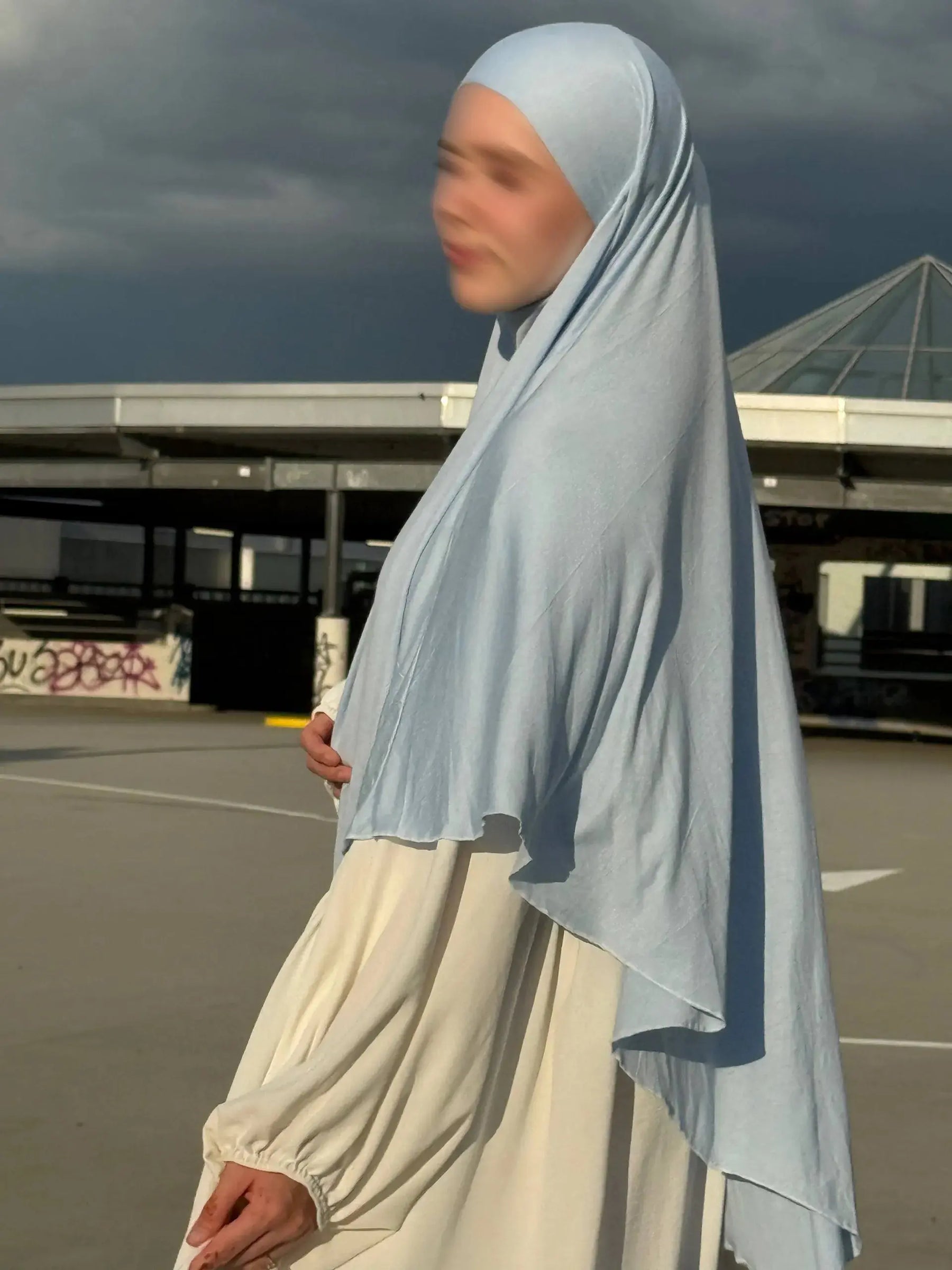 Jersey Khimar hellblau aus 95% Viskose und 5% Elastan, seitliche Ansicht mit langer Rückenpartie.