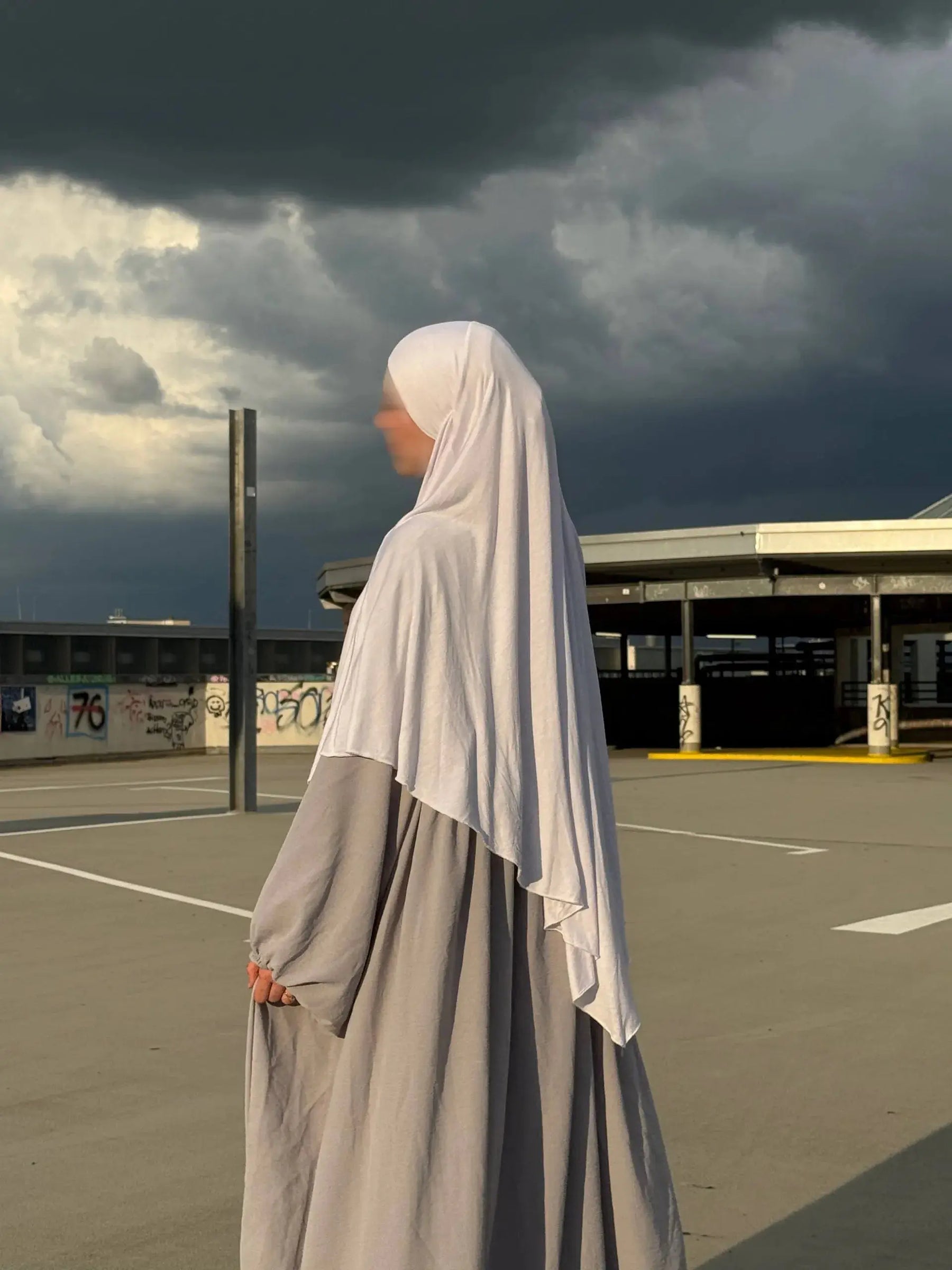 Jersey-Khimar in hellbeige aus 95% Viskose/5% Elastan, seitliche Ansicht mit deutlich fallendem Rückenteil.