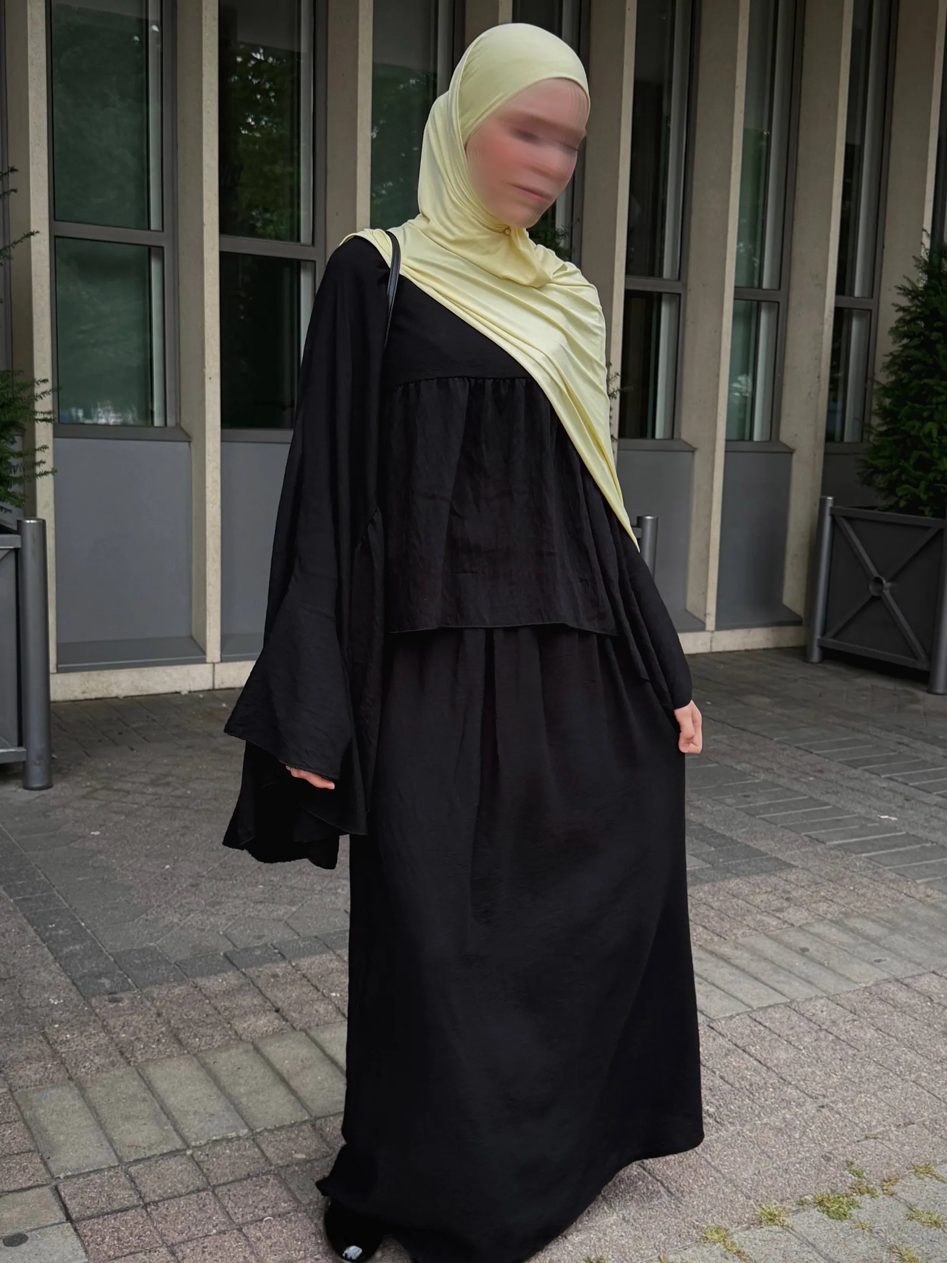 schwarzer zweiteiler mit weitem oberteil, glockenärmeln und langem maxirock, frontansicht