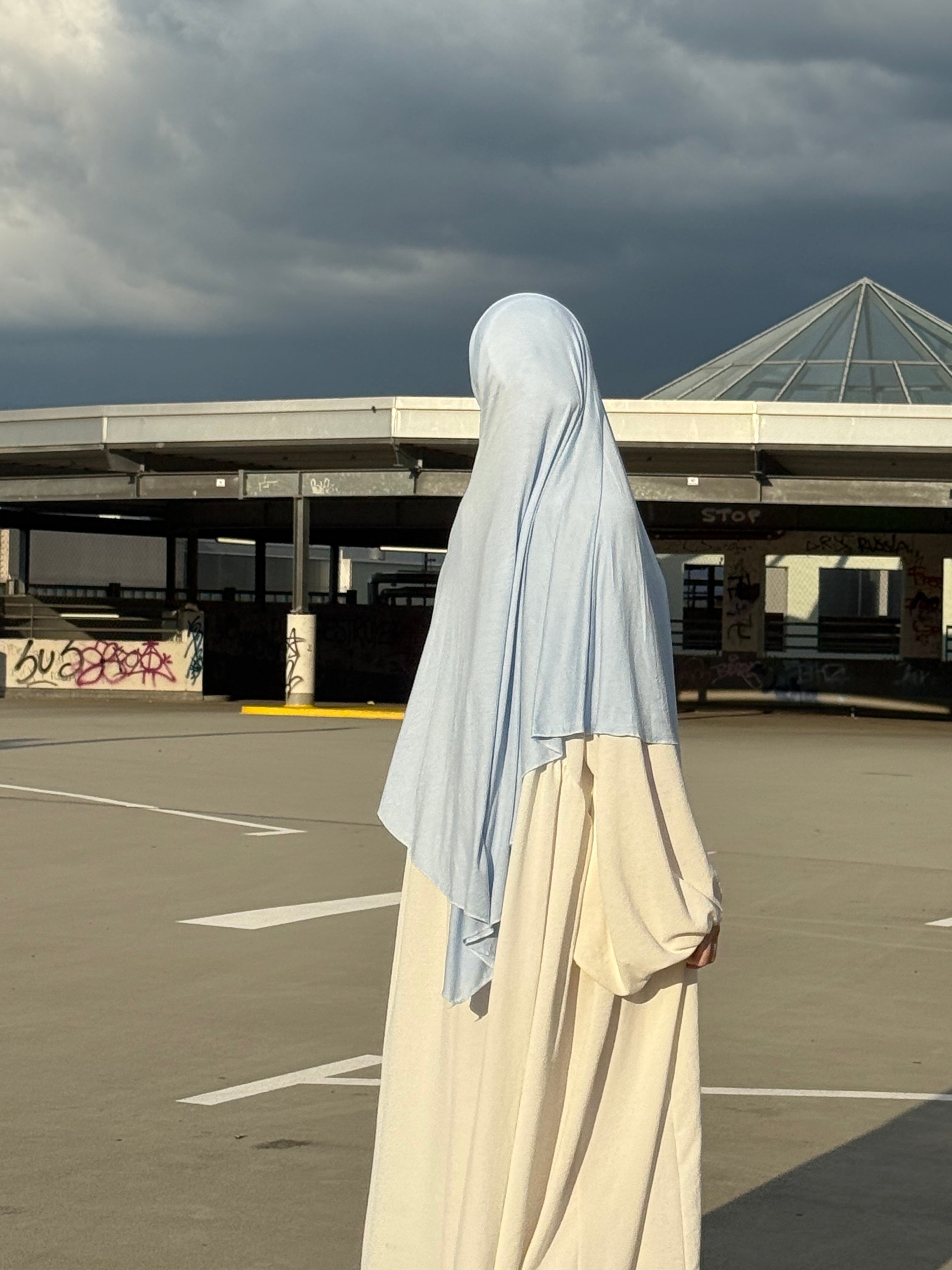 Der hellblaue Jersey Khimar aus Viskose und Elastan ist in seitlicher Rückenansicht zu sehen.