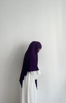 Jersey Khimar in dunklem Violett aus Viskose‑Elastan, seitliche Ansicht an einer stehenden Person.