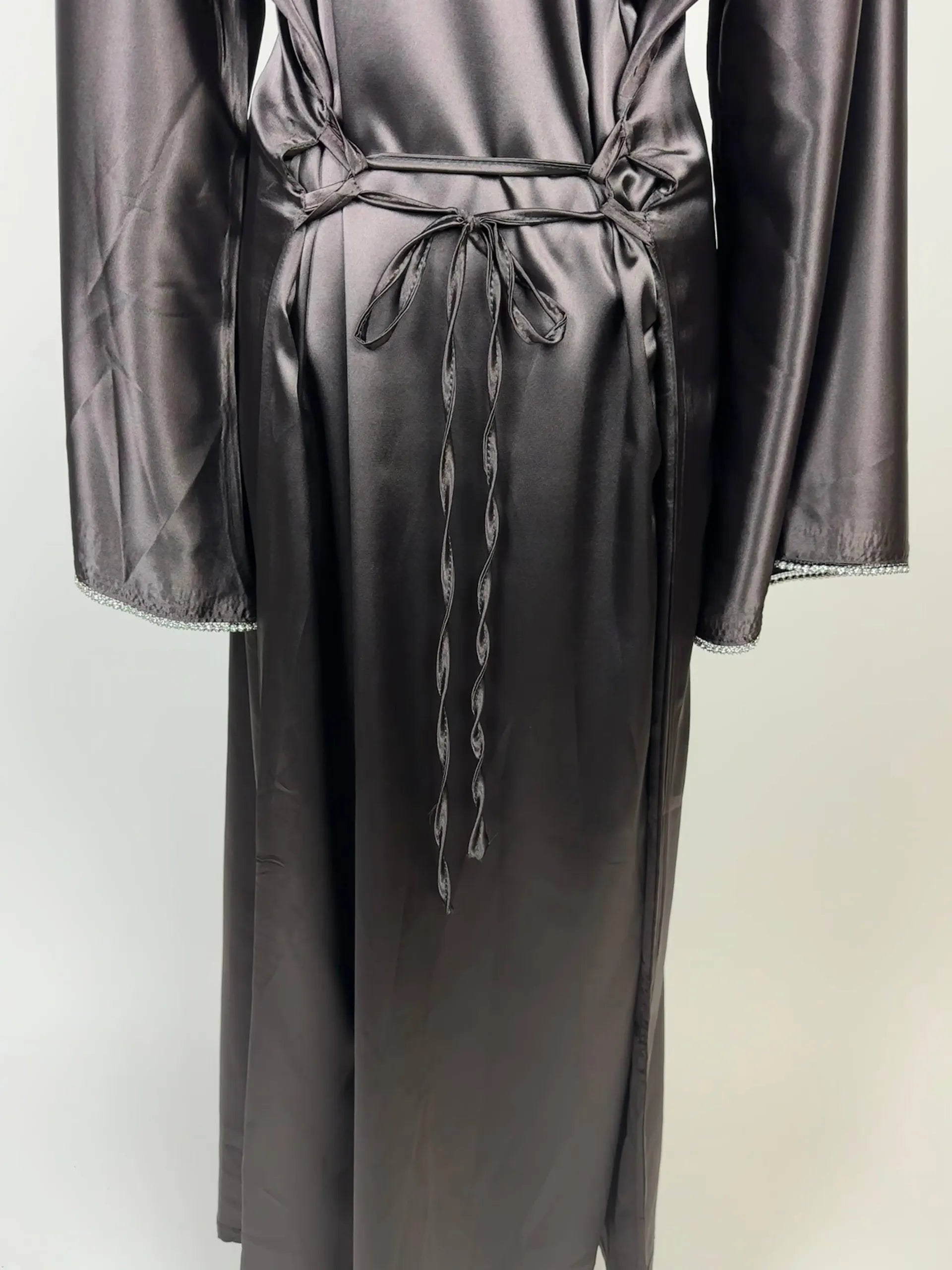 Graphitgraue Abaya aus Polyester in Satin-Optik mit Taillenschnüren und Perlenbesatz an den Ärmeln, Vorderansicht