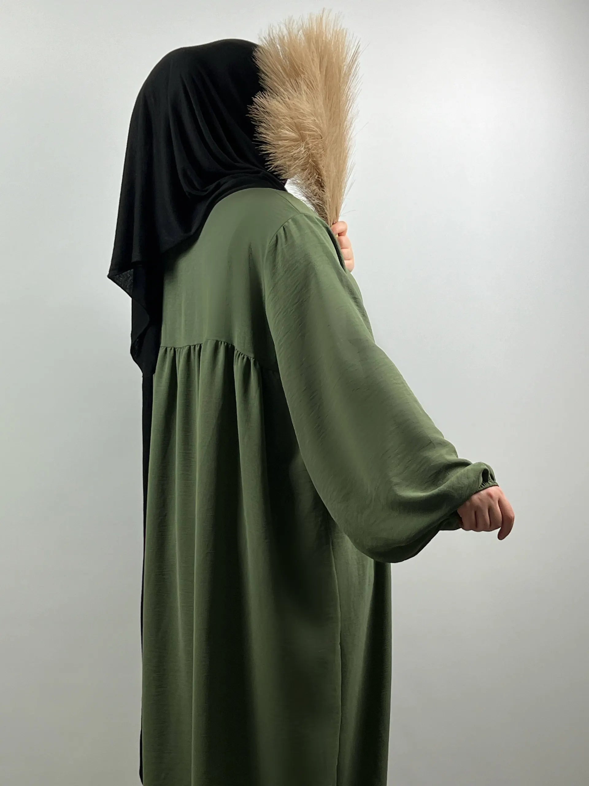 Olivgrüne Abaya aus Jazz-Stoff mit Ballonärmeln, seitliche Ansicht.