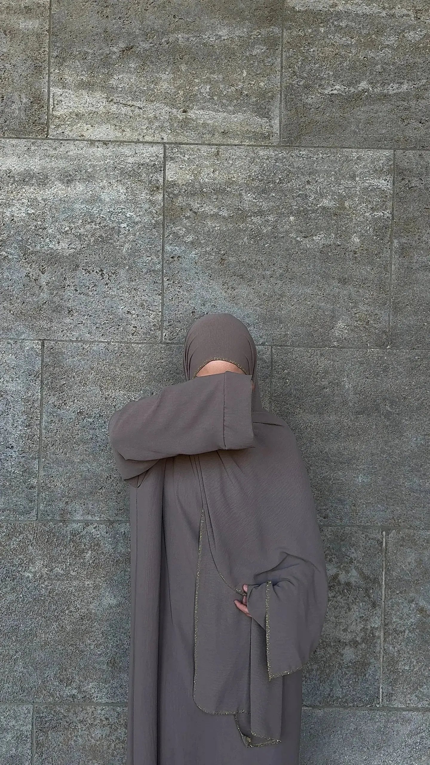 Taupefarbene Einteiler-Abaya aus fließendem Stoff mit integriertem Hijab und goldener Kante, Vorderansicht