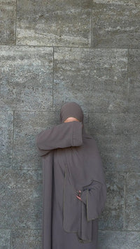 Taupefarbene Einteiler-Abaya aus fließendem Stoff mit integriertem Hijab und goldener Kante, Vorderansicht