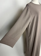 Taupefarbene Basic-Abaya aus Jazzstoff mit weiten Ärmeln, Detailansicht der linken Seite.